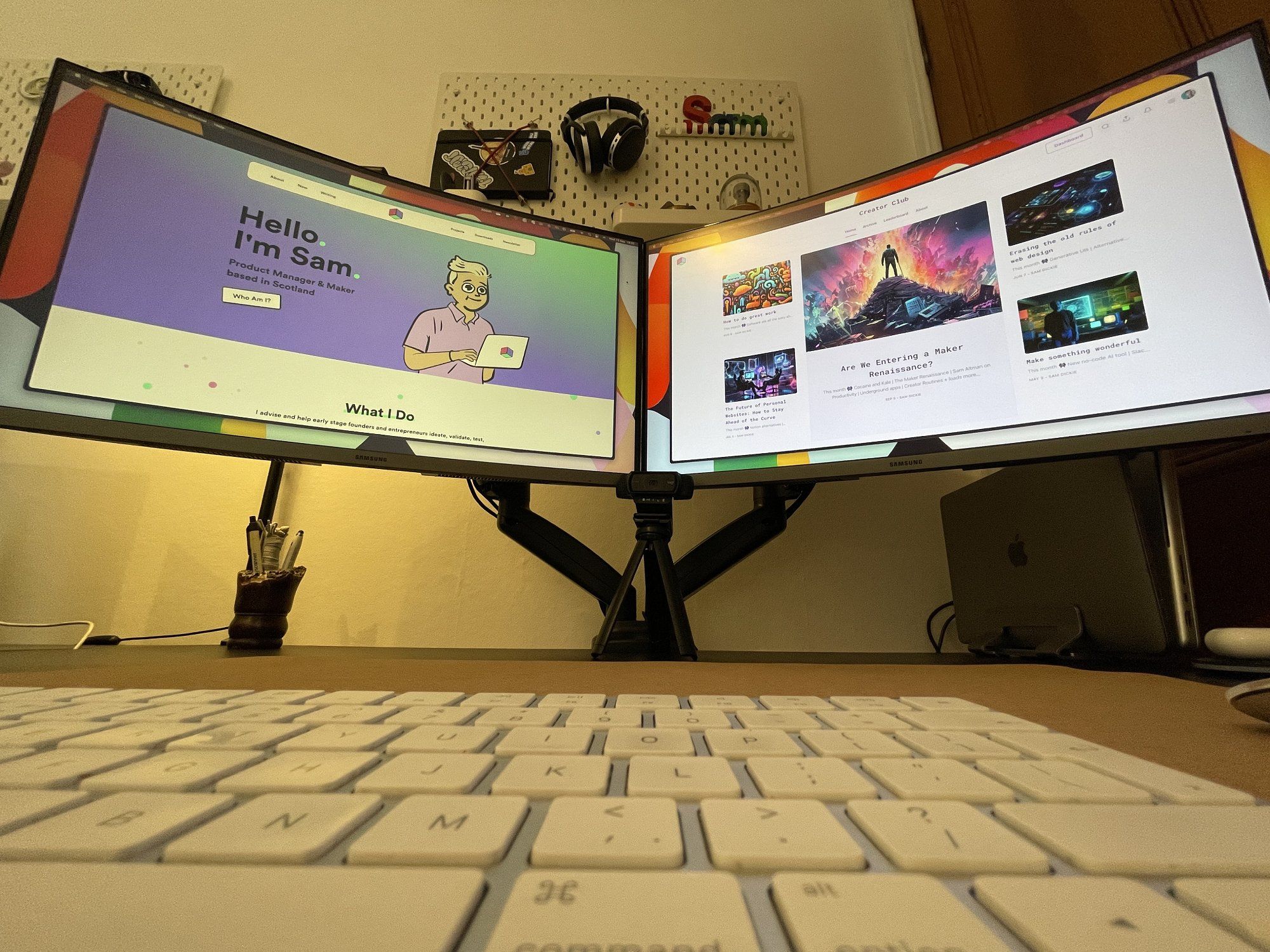 A wide angle shot of an Apple Magic keyboard and two Samsung monitors