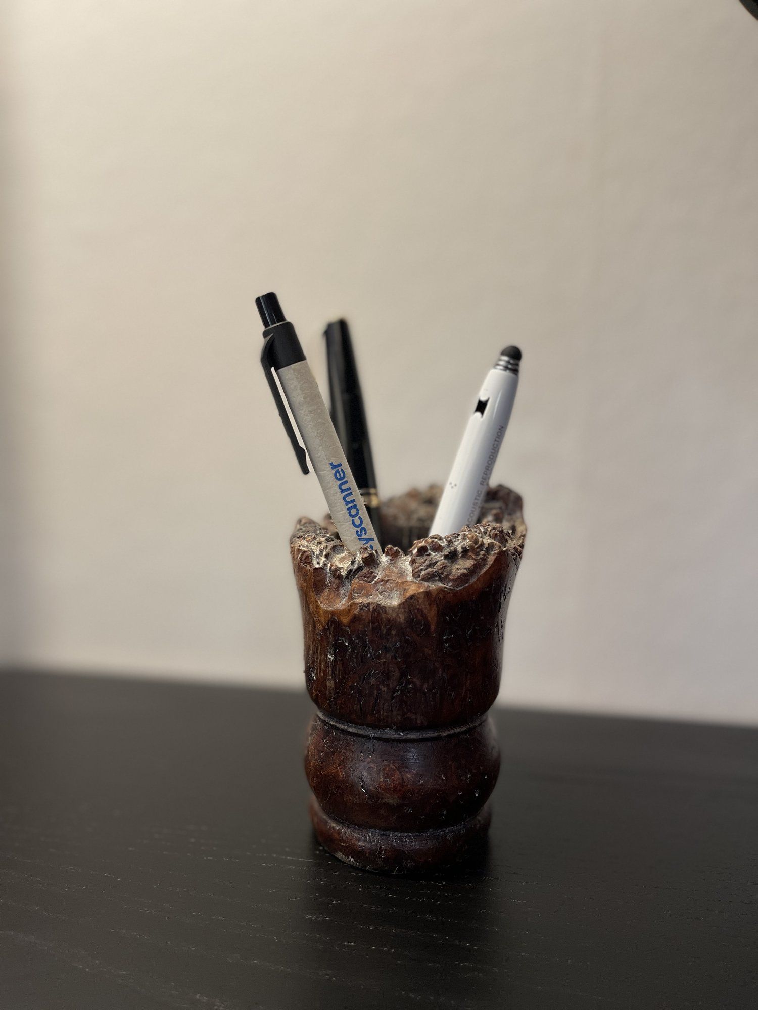A wooden pen holder with three pens