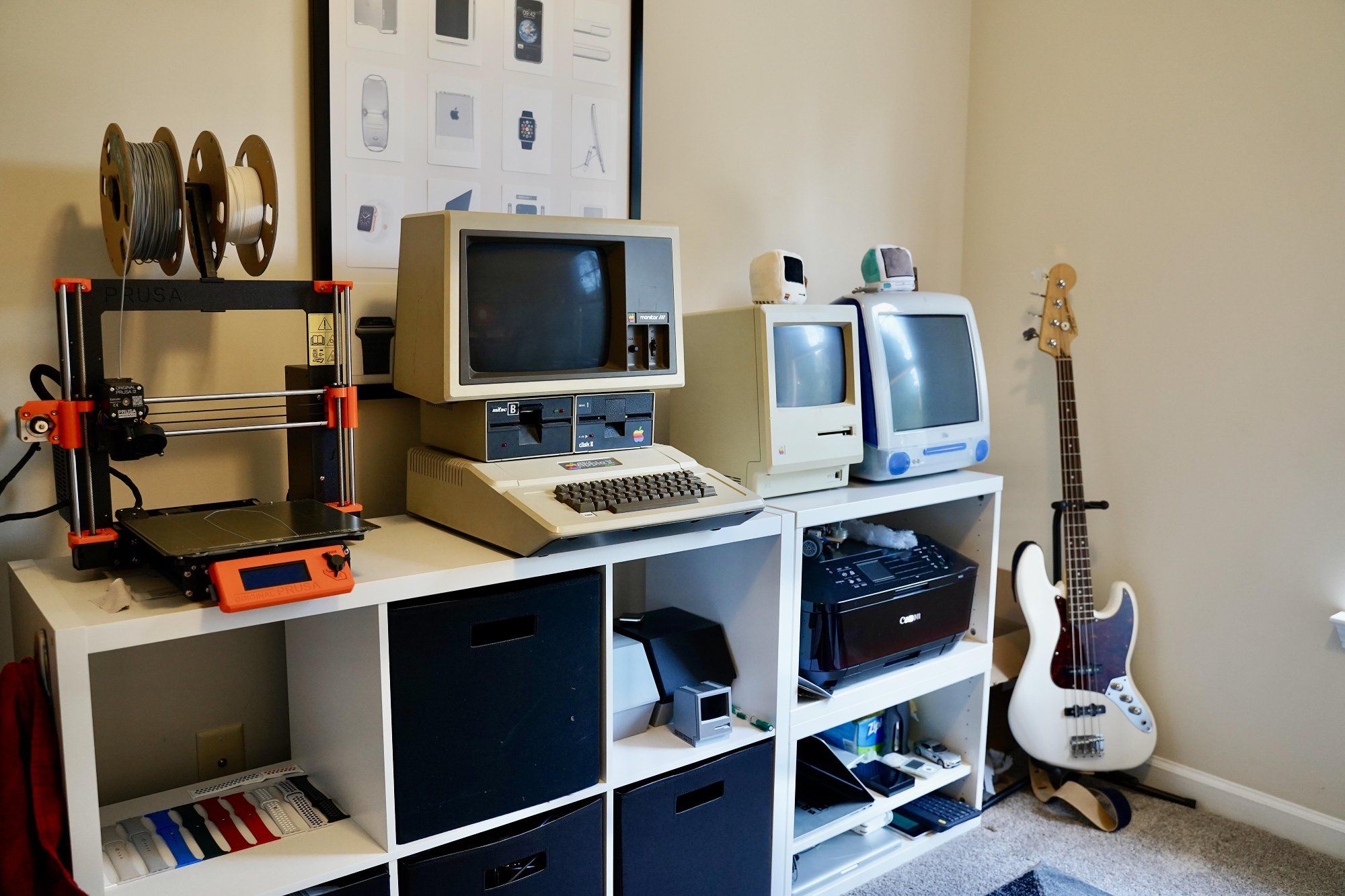 A collection of vintage Apple computers, plus a guitar in the corner