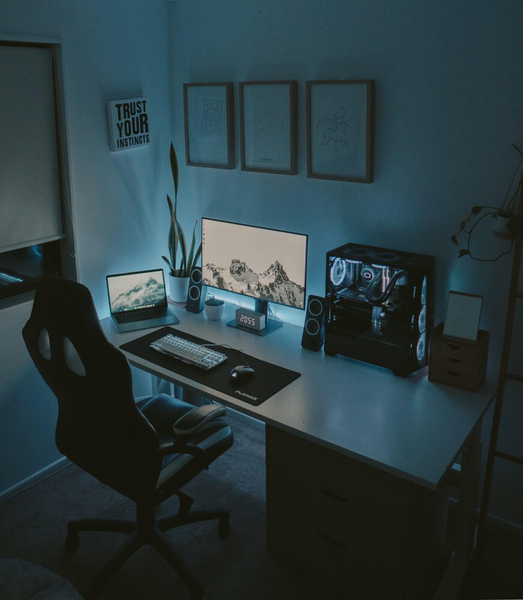 A Scandinavian-style workspace with minimal design, featuring an RGB-lit custom PC, dual monitors, ergonomic office chair, and ambient lighting
