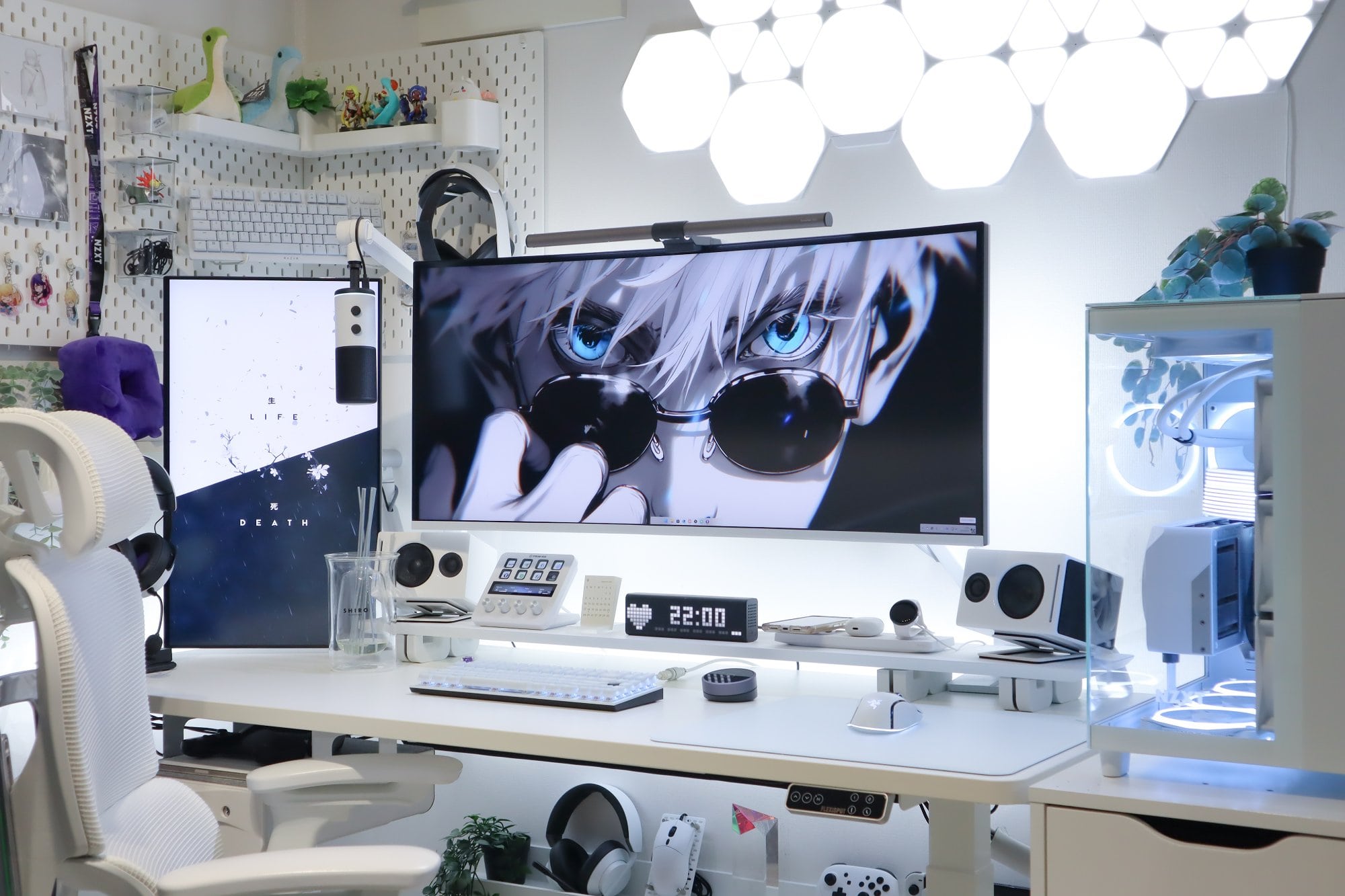 A modern and stylish desk setup with a monochromatic colour scheme, featuring an ultrawide monitor displaying an anime character, flanked by speakers and various tech gadgets