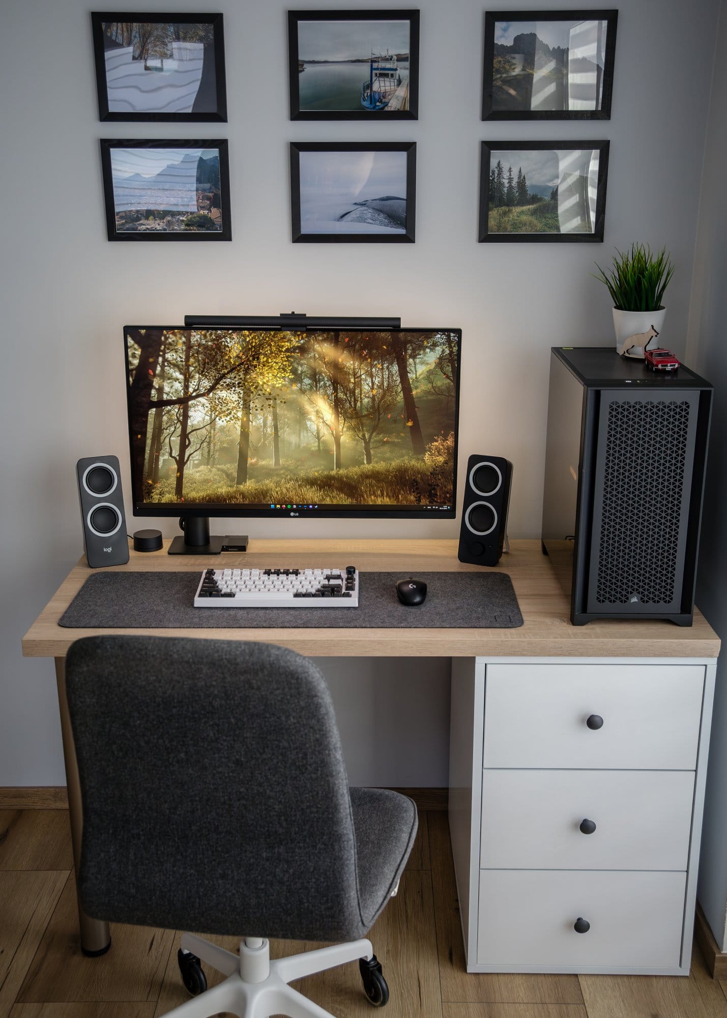 An elegant home office setup with a large monitor on a wooden desk, accompanied by stereo speakers, a mechanical keyboard, and an ergonomic mouse