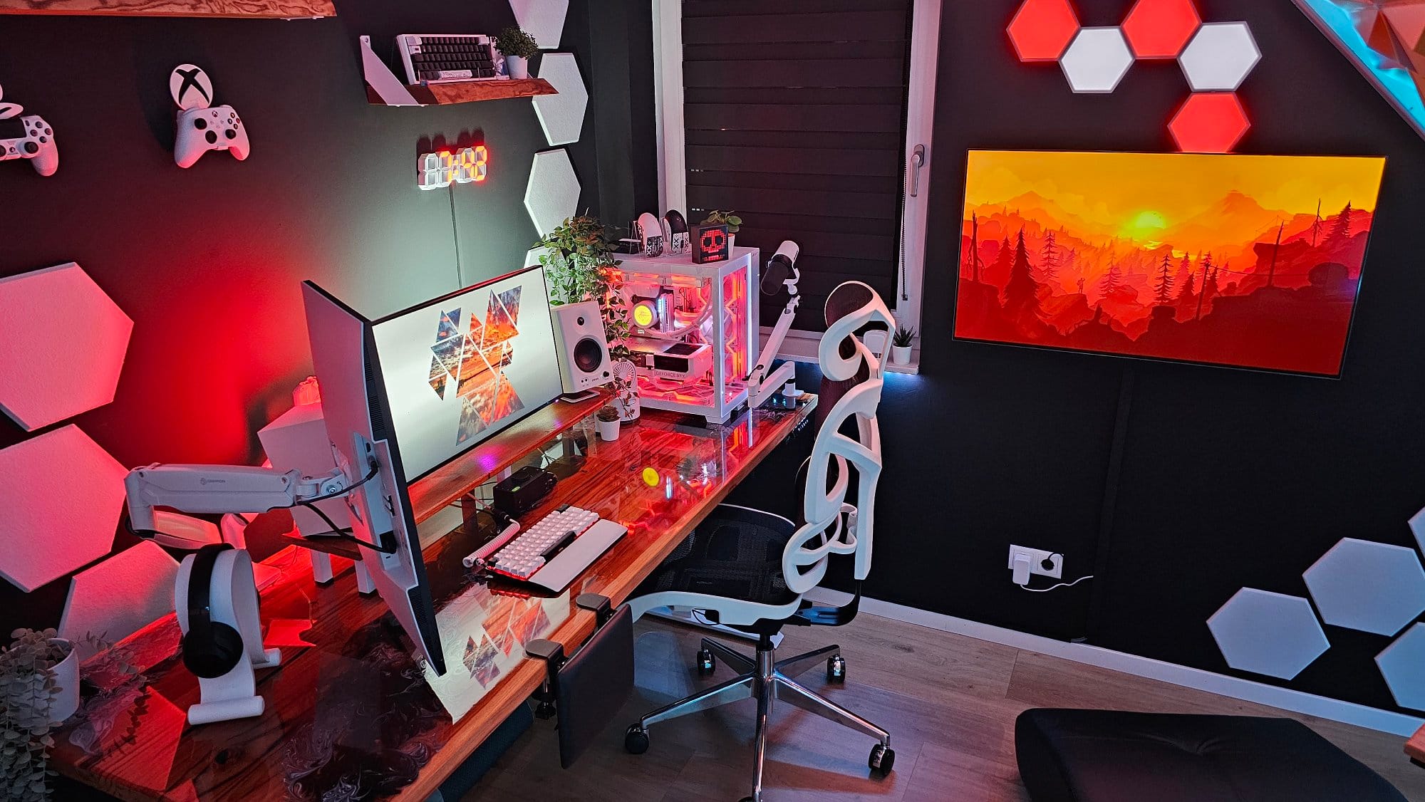 A gaming and workstation setup with a dual-monitor display, a white ergonomic chair, a custom PC with lighting, floating shelves, and decorative wall panels, illuminated by red and blue ambient lights