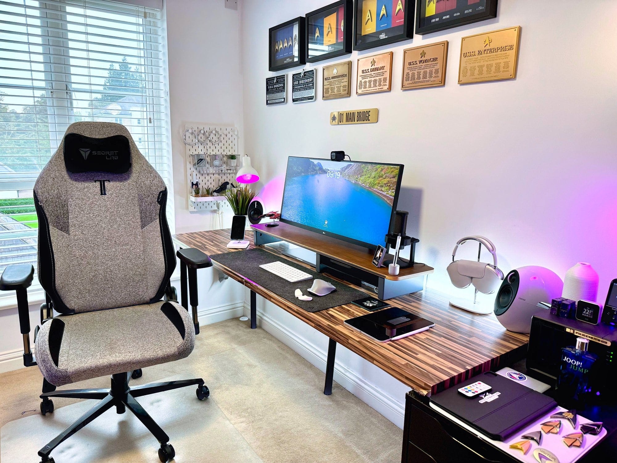 A comfortable home office setup with a large window, a textured gaming chair, a wooden desk