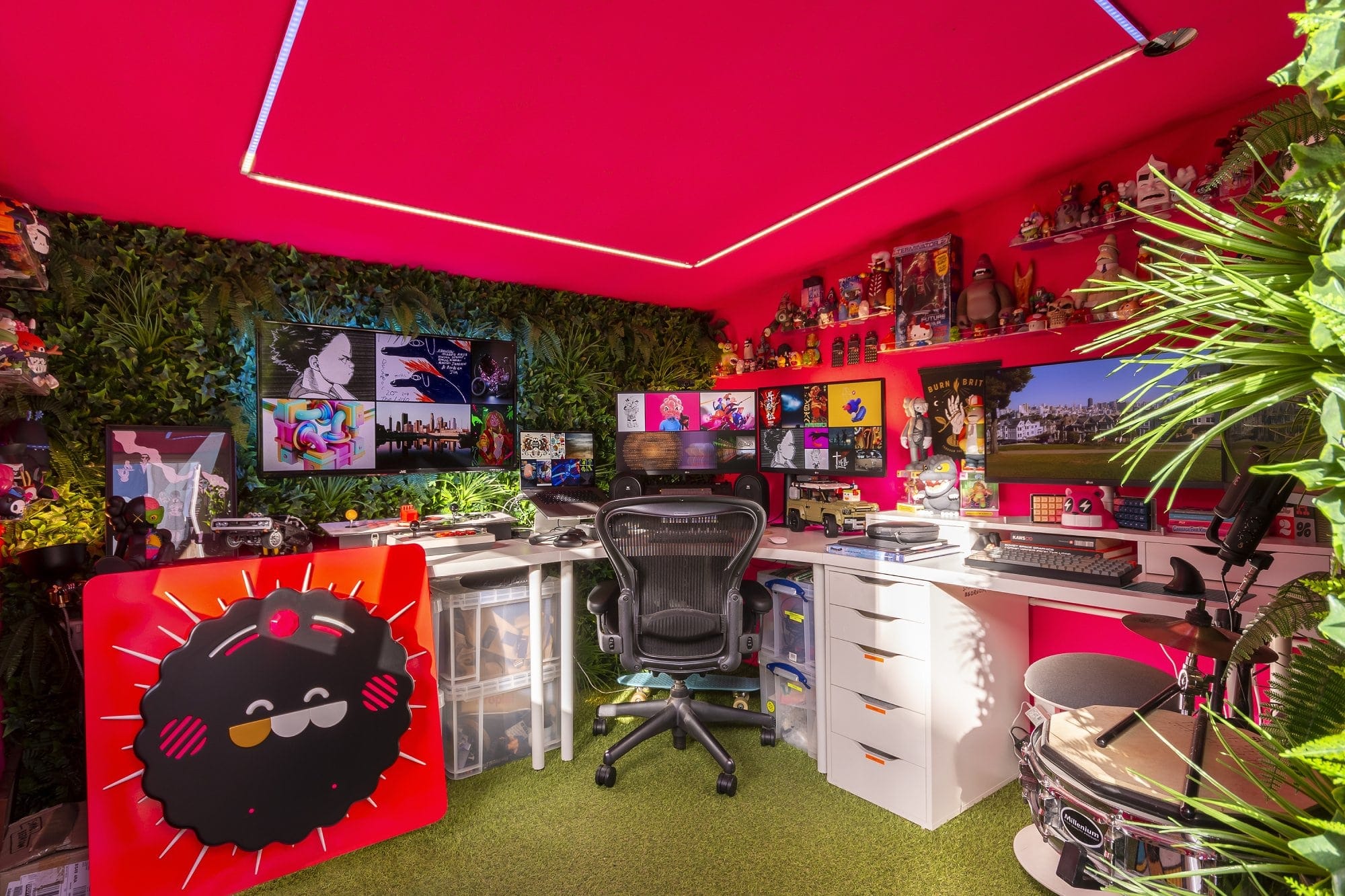 A neon pink home workspace with artificial plants