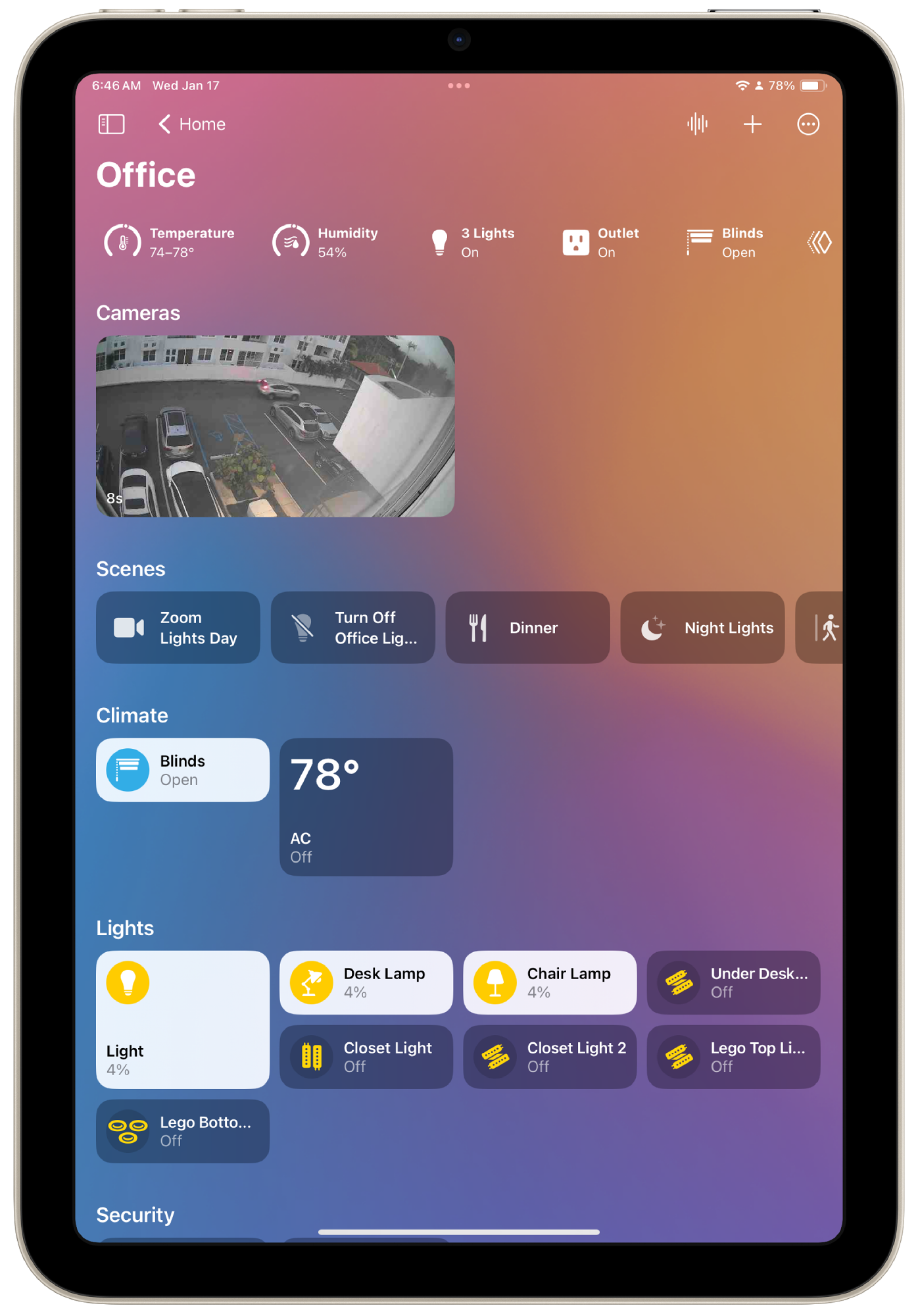 A tablet displaying a smart home control interface showing office temperature, humidity, lighting status, a live camera feed, and controls for various scenes and devices like climate and security