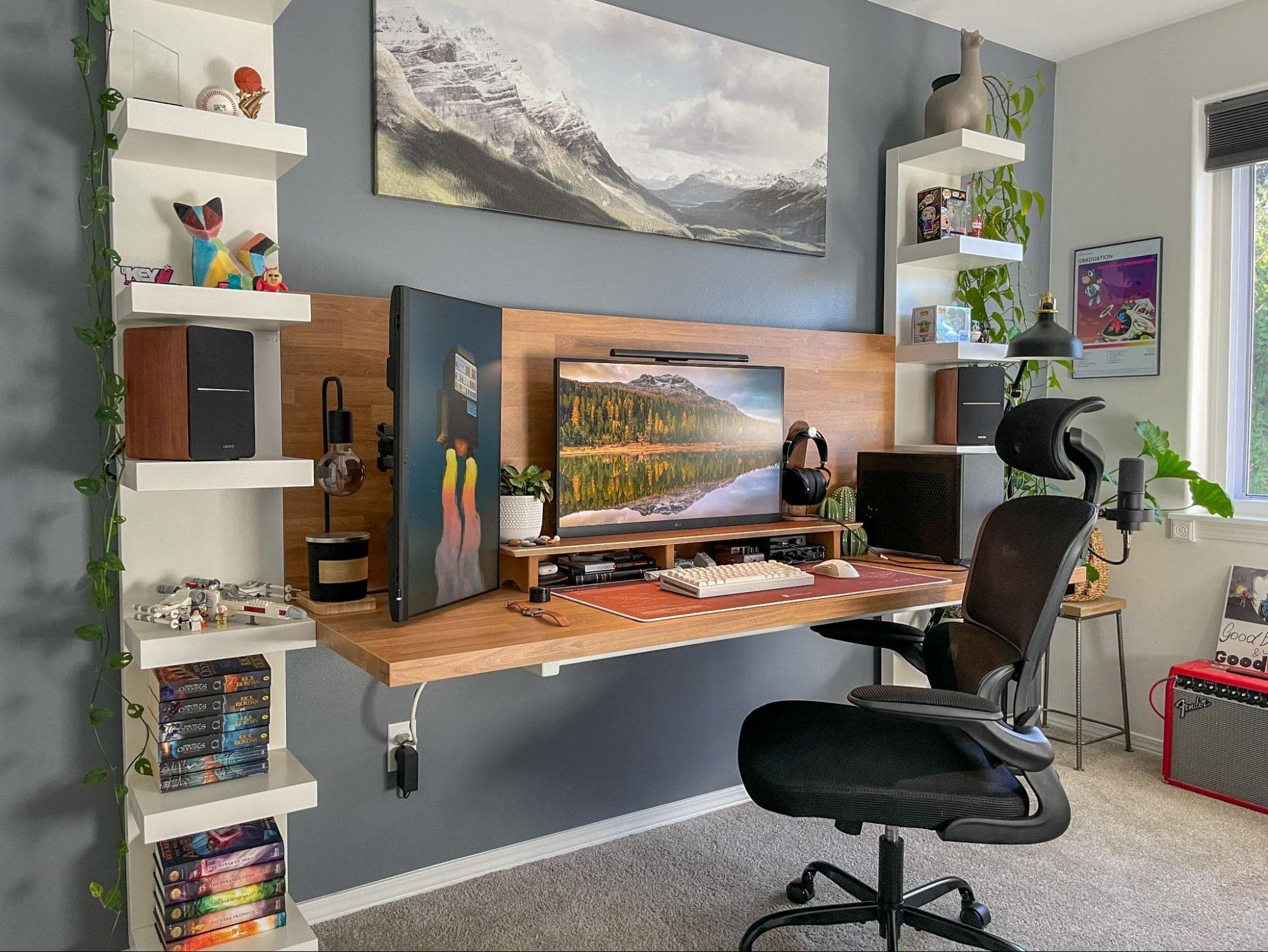 A spacious home office with an ergonomic chair, wooden floating desk with monitors, surrounded by shelving with plants and decor, and a guitar amplifier in the corner, under ambient lighting