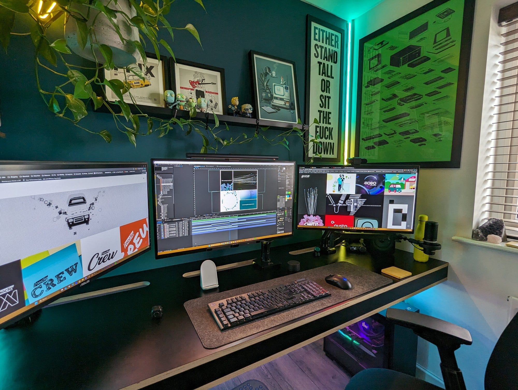 A modern home office workspace featuring a triple-monitor setup on a sleek desk, accented by vibrant green plants, framed art, motivational posters, and colourful LED lighting