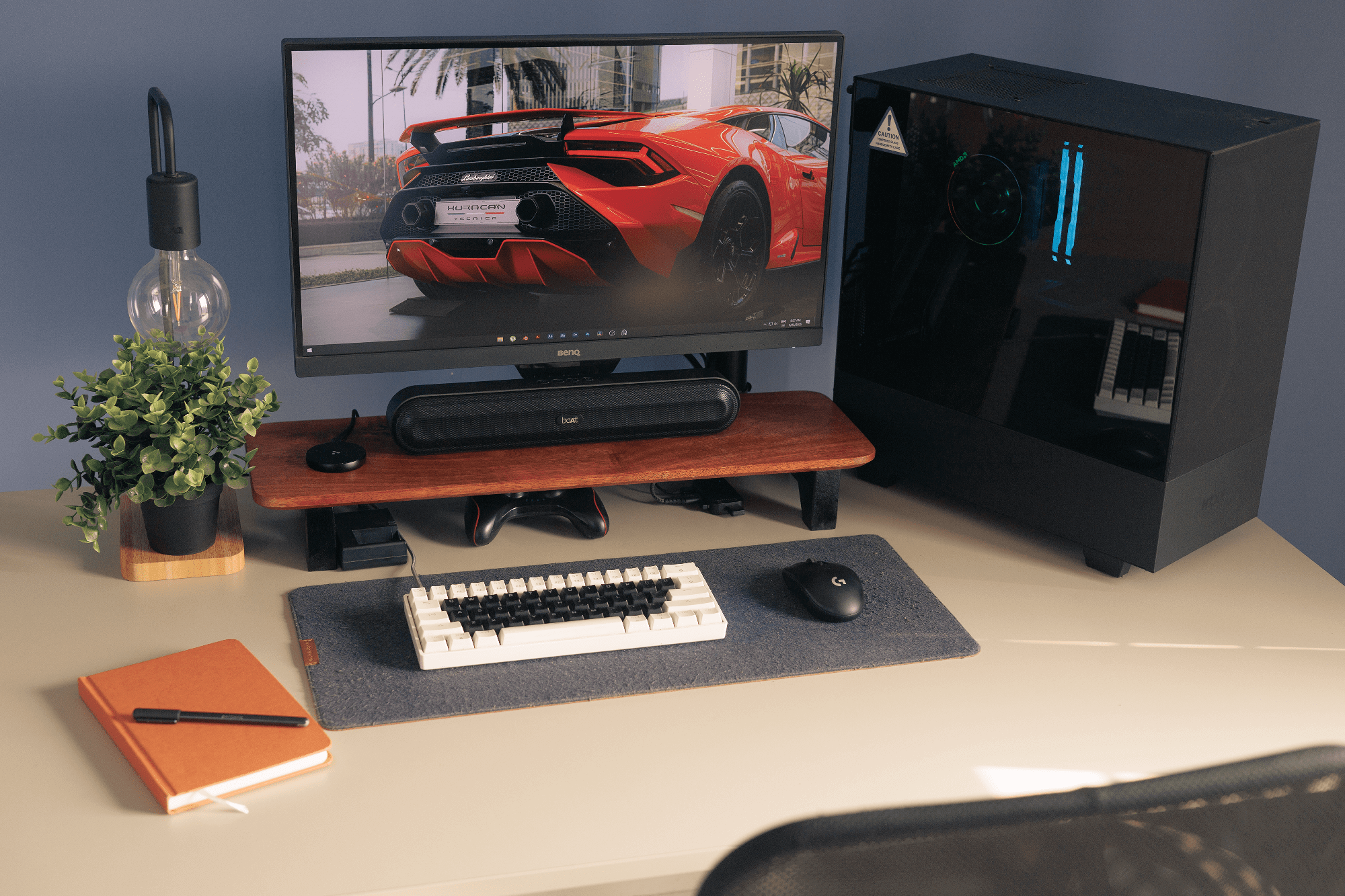 A home office with a BenQ PD2500Q monitor, boAt Aavante Bar 490 speaker, and IKEA TVÄRHAND lamp