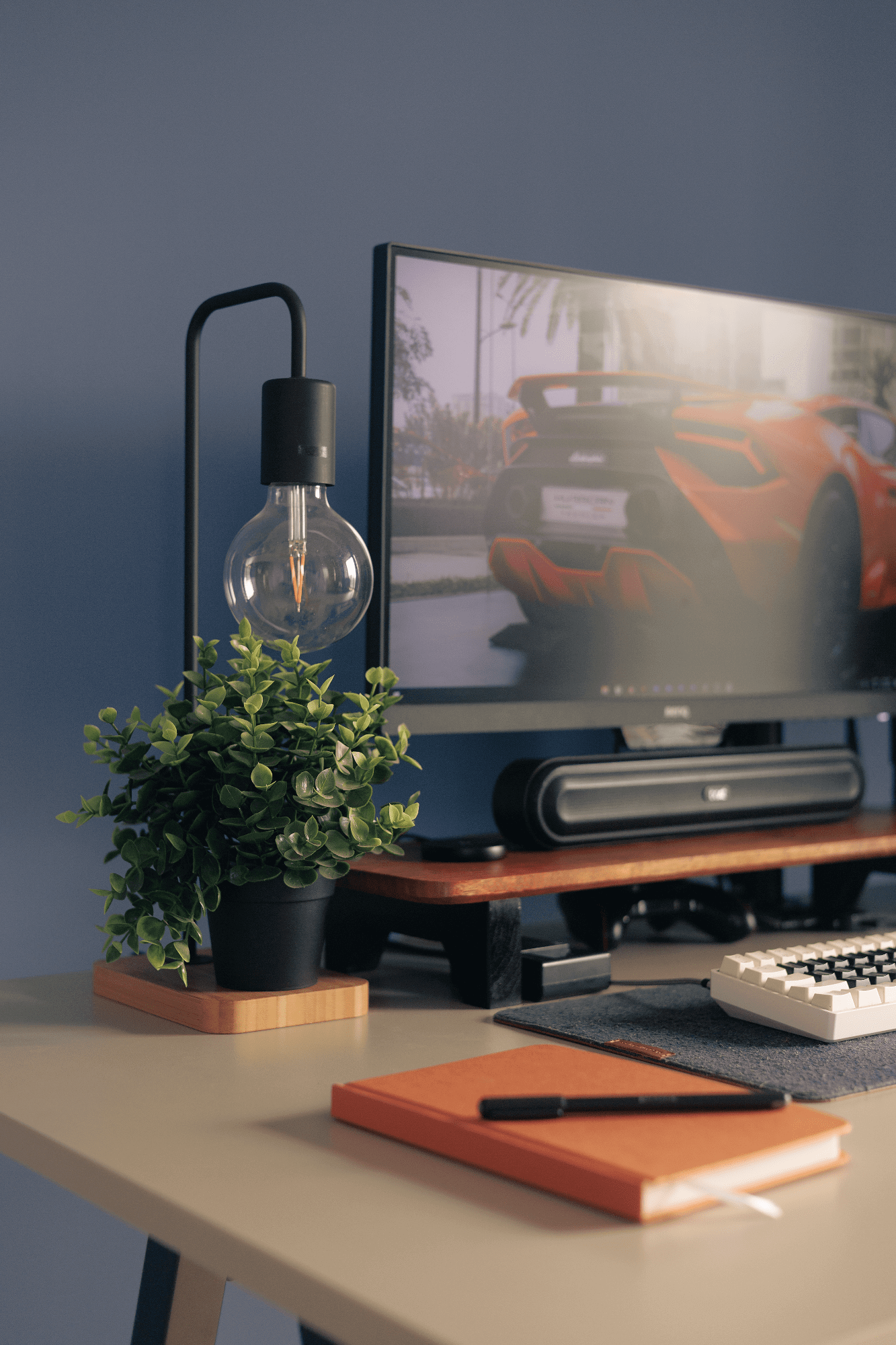 A home office desk with an IKEA TVÄRHAND lamp, an IKEA FEJKA plant, and an EPOMAKER Skyloong SK61 keyboard