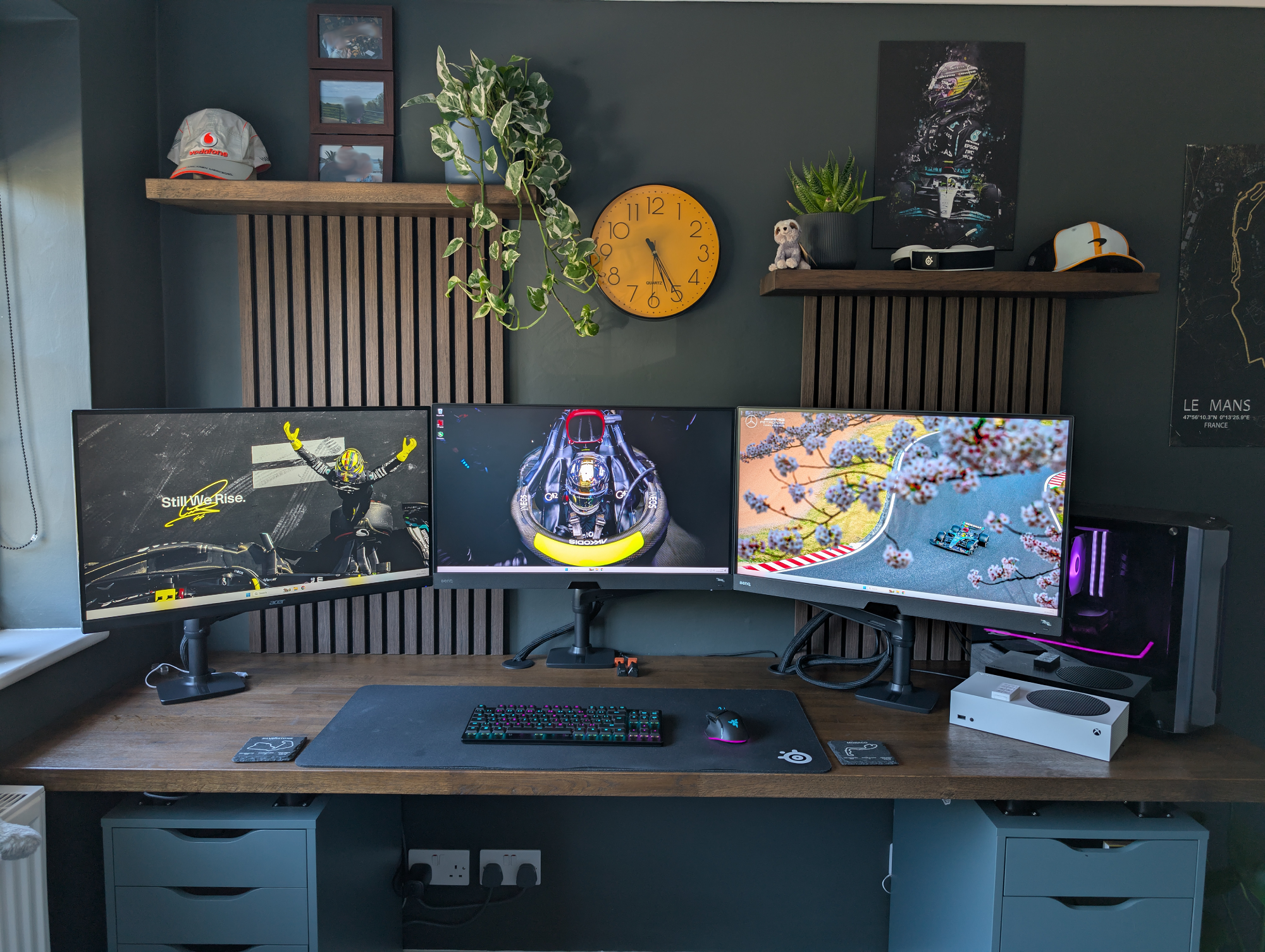 A triple-monitor desk setup with a Razer Deathstalker V2 Pro keyboard, Razer Basilisk V3 Pro mouse, Xbox Series S, and two IKEA ALEX drawers