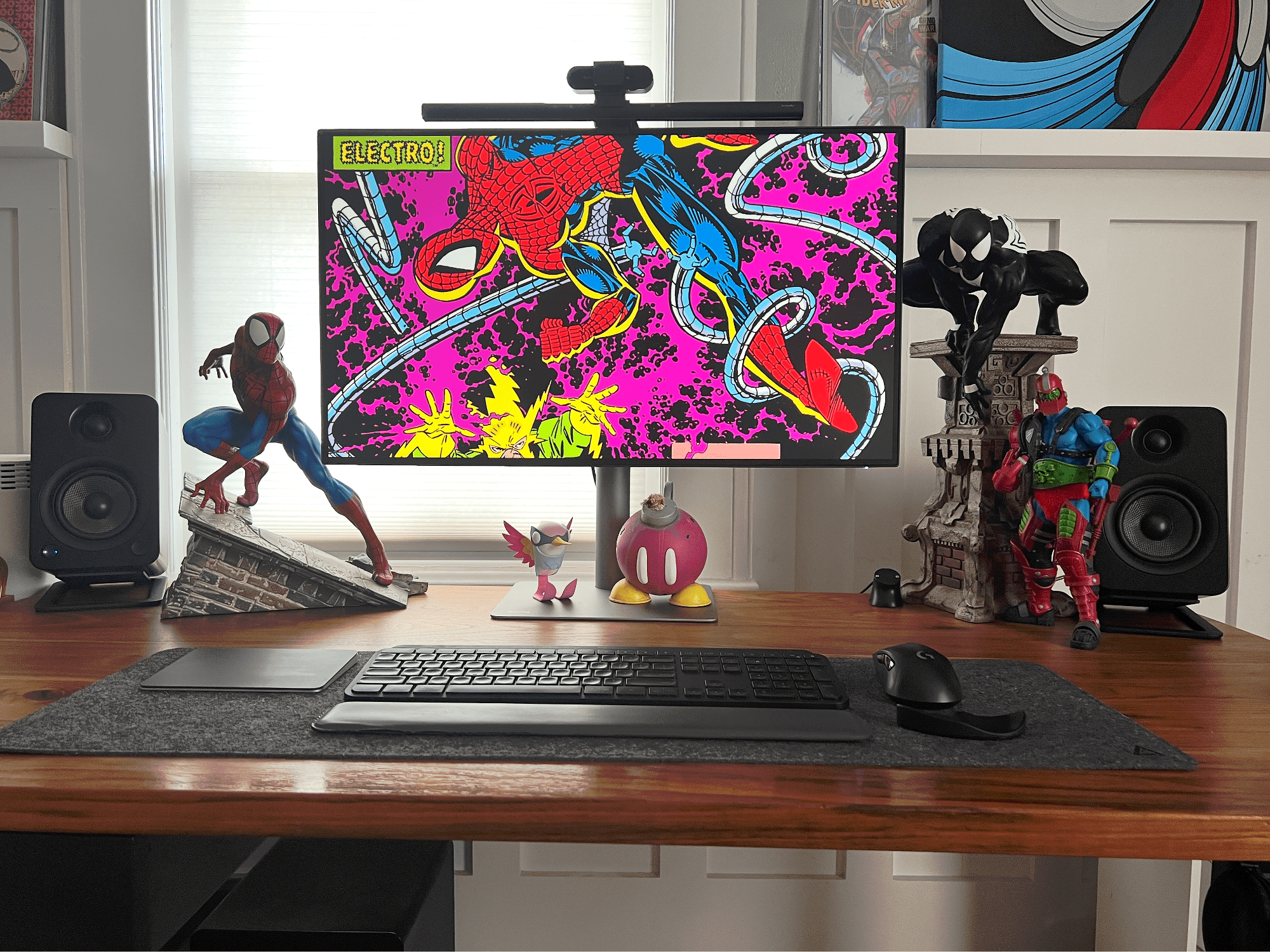 A Spider-Man themed desk with BenQ monitor, Logitech MX Keys keyboard and Kanto YU4 speakers
