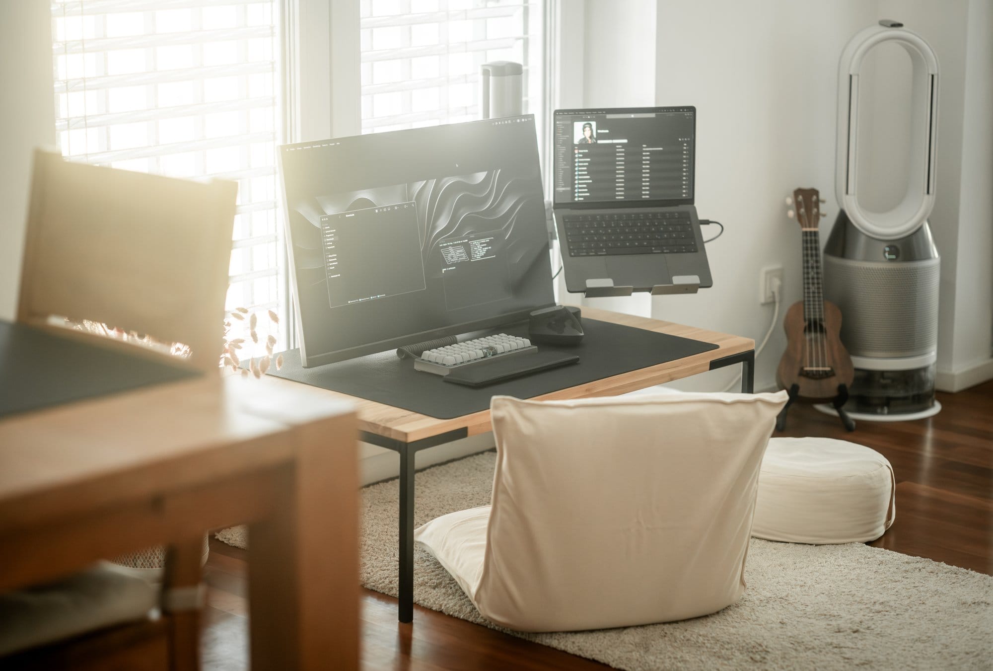 A low desk setup with Acer Nitro, MacBook Pro, and Planck keyboard