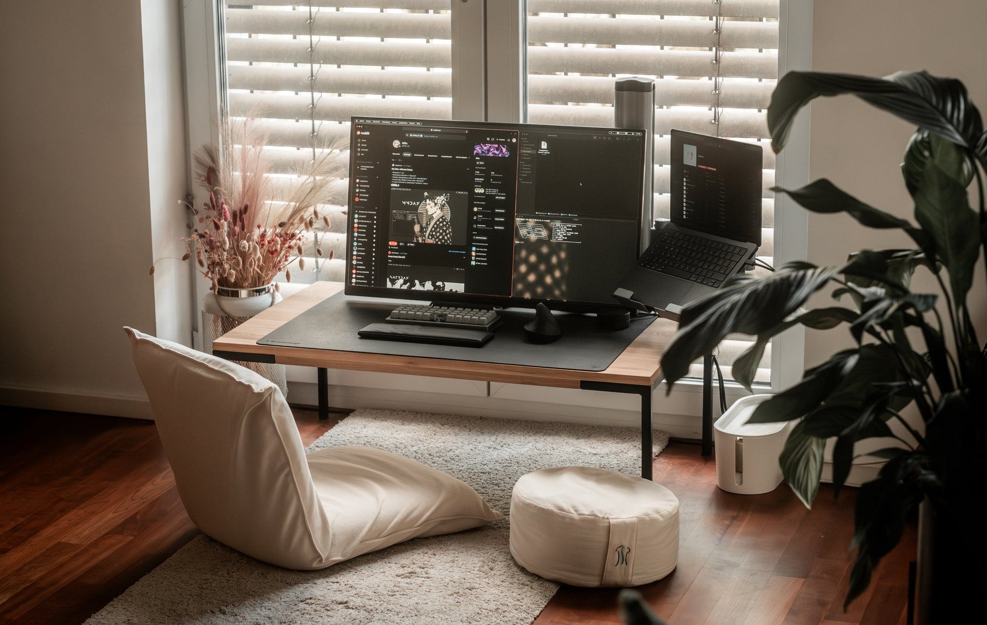 A home office setup with Acer Nitro, MacBook Pro, and MUJI floor chair