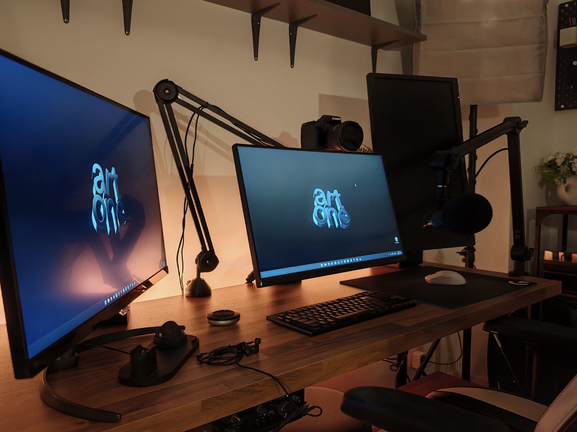 A desk with two monitors and a Logitech G915 TKL keyboard