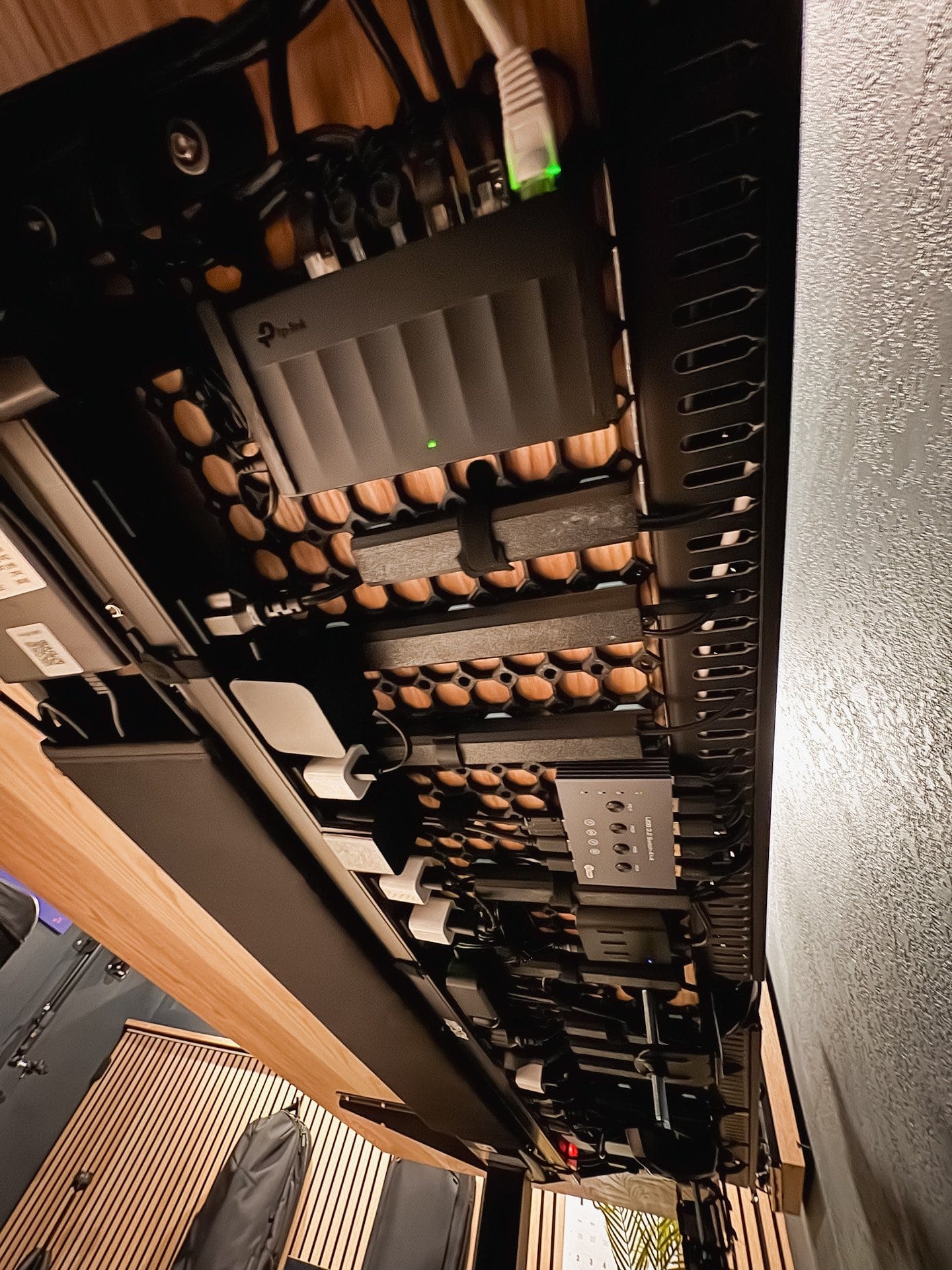under desk cable management setup with mounted power strips, ethernet switch, and neatly organized wires for a clean workspace