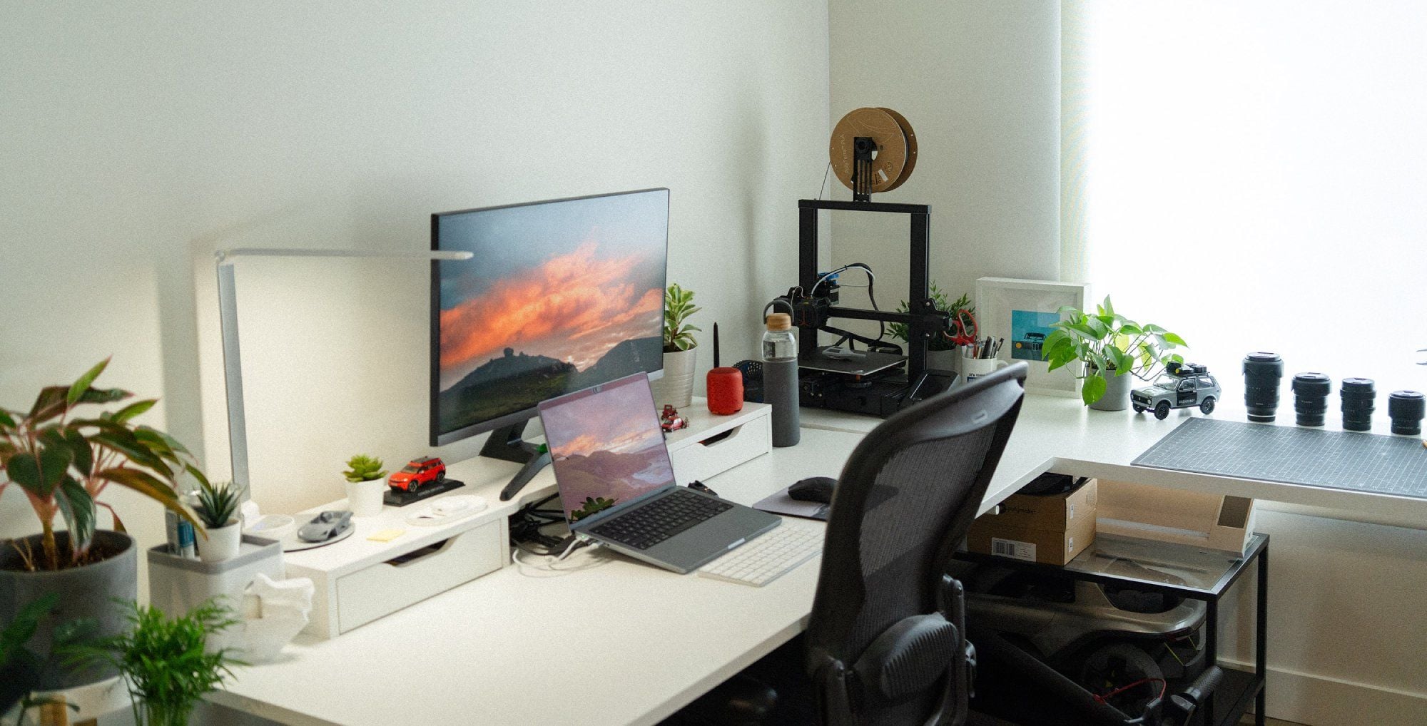 A corner desk setup by the window in a designer’s home office