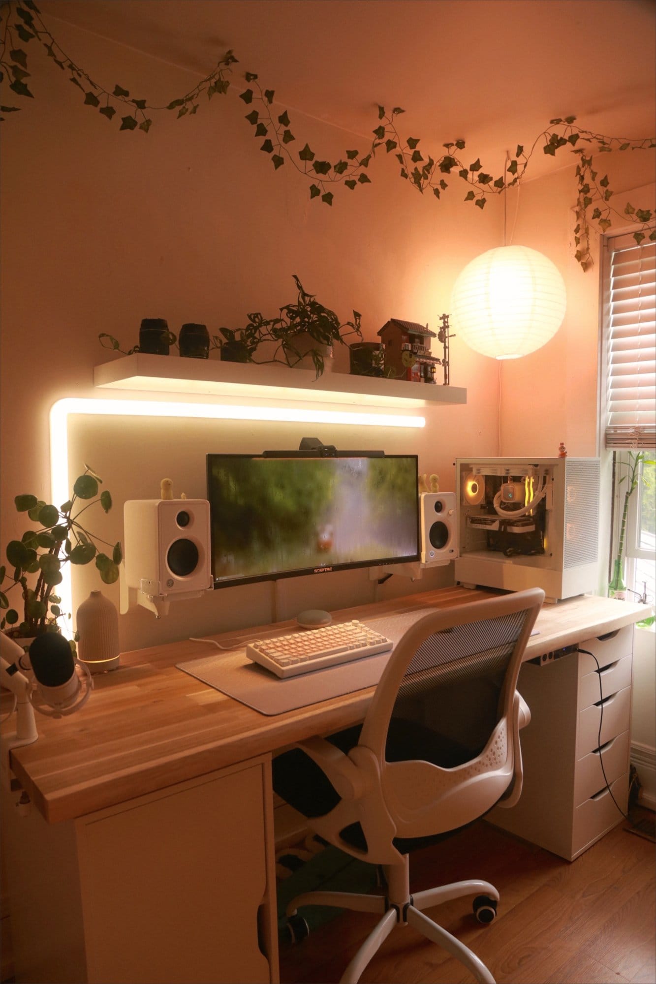 A cosy workspace with a Sceptre 30″ Ultrawide monitor, Mackie CX3 speakers, and an AKKO MOD 007 PC keyboard, featuring ambient lighting, plants, and a Kerdom office chair