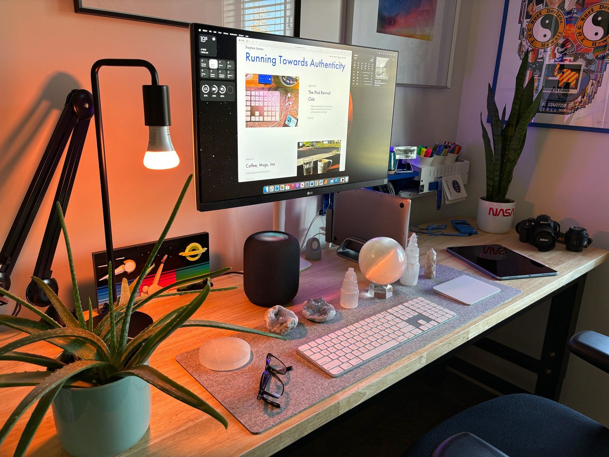 A home office setup with an LG 27″ IPS 4K UHD monitor, an Apple Magic Keyboard with Touch ID, an Apple Magic Trackpad, a RØDE PSA1 boom arm, and a BeaverPeak Felt Desk Pad on a Husky workbench
