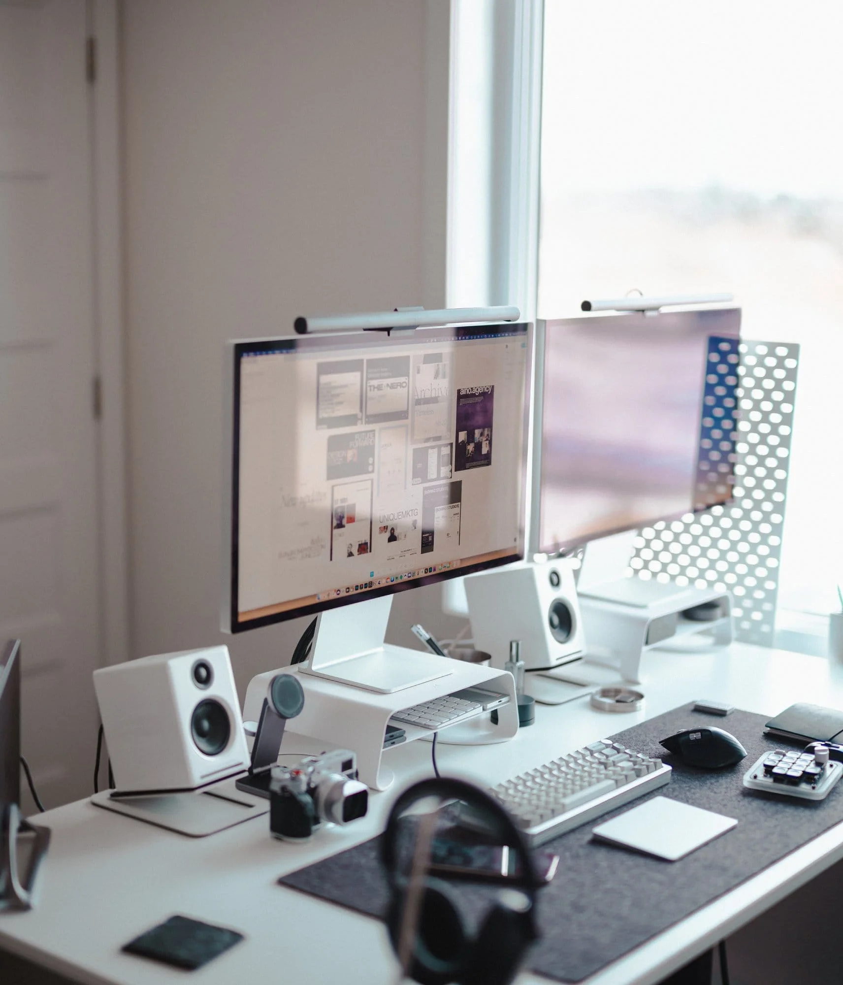 A dual Apple Studio Display setup with Xiaomi Mi Light Bars, Audioengine A2s speakers, a custom mechanical keyboard, a Logitech MX Master 3S mouse, and Sony XM5s on a felt Grovemade desk pad