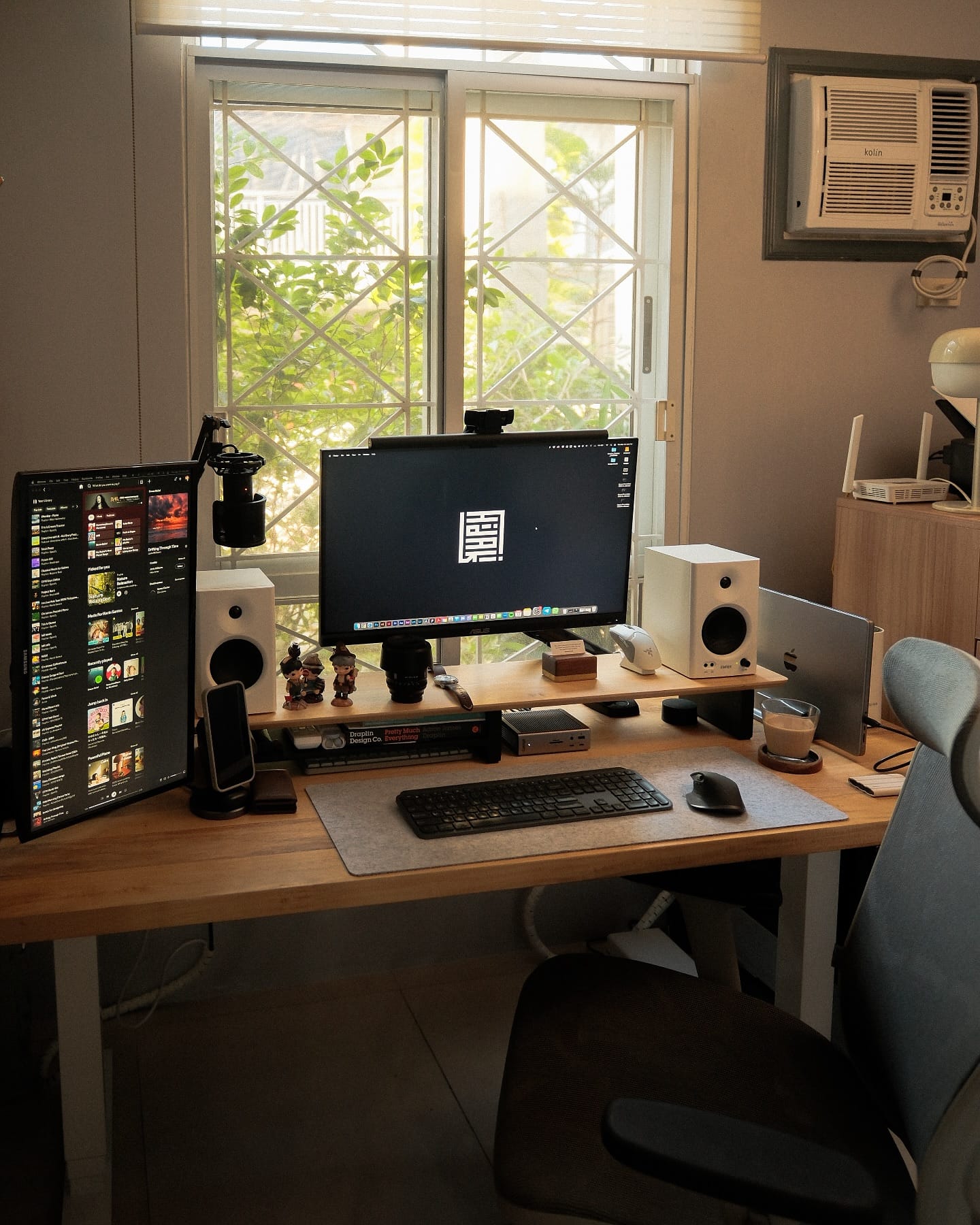 A home office desk setup with two monitors, Edifier MR4 speakers, a Logitech MX Keys keyboard, and a Logitech MX Master 3S mouse on a wooden desk with a felt mat