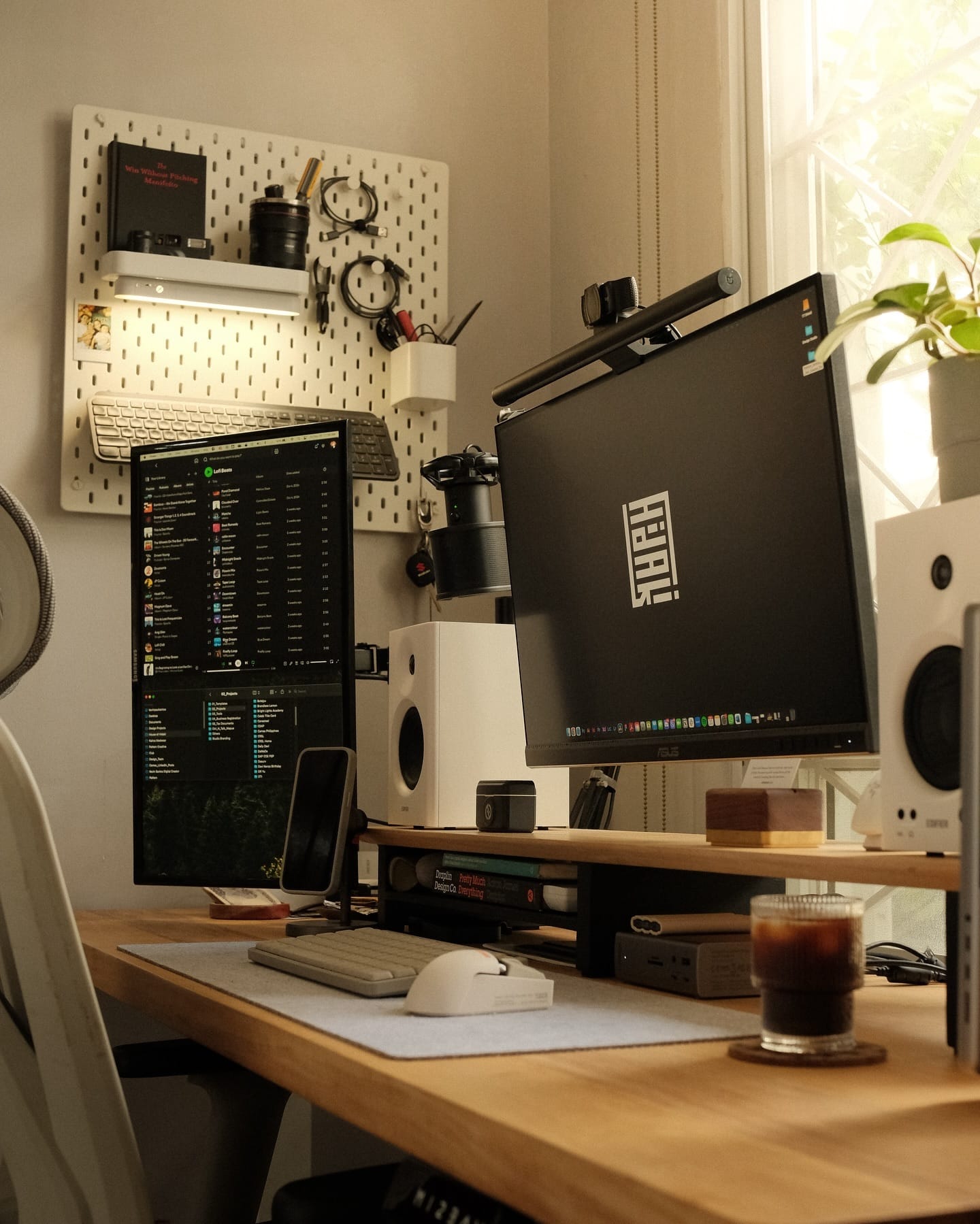 A dual-monitor home office setup with a Razer Viper Ultimate Wireless mouse, an Akko 5075B Plus keyboard, and Edifier MR4 speakers on a wooden desk with a pegboard wall organiser