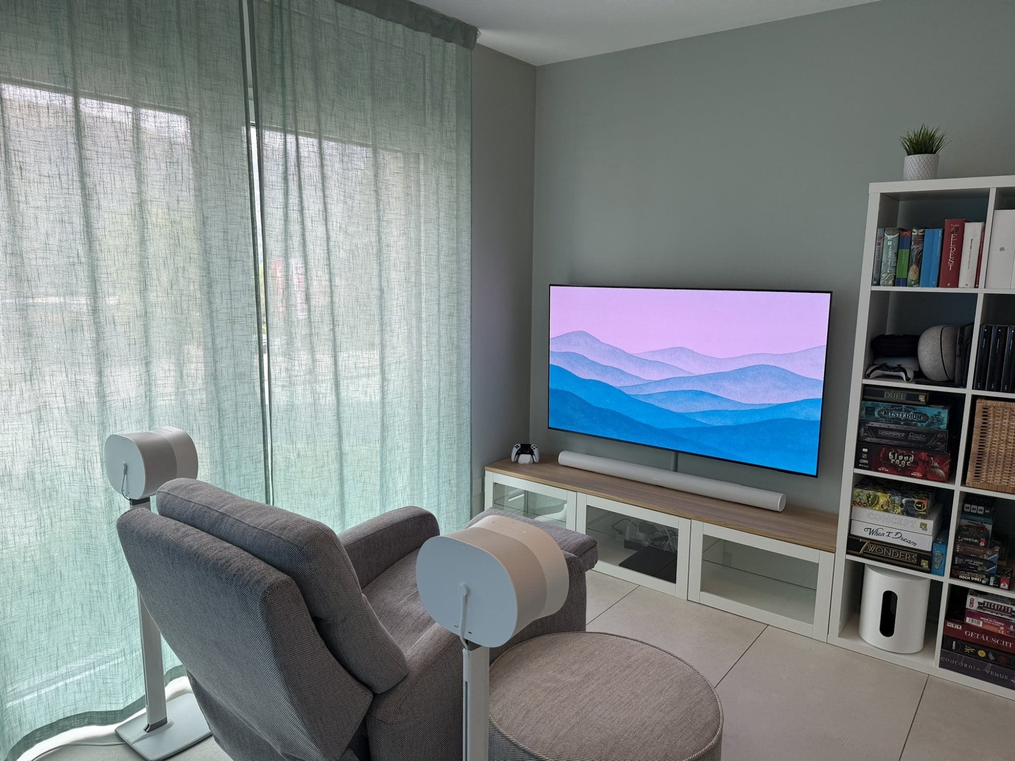 A gaming corner with a Samsung S95D OLED TV, Sonos Arc soundbar, Sonos Sub Mini, and board games on IKEA shelving