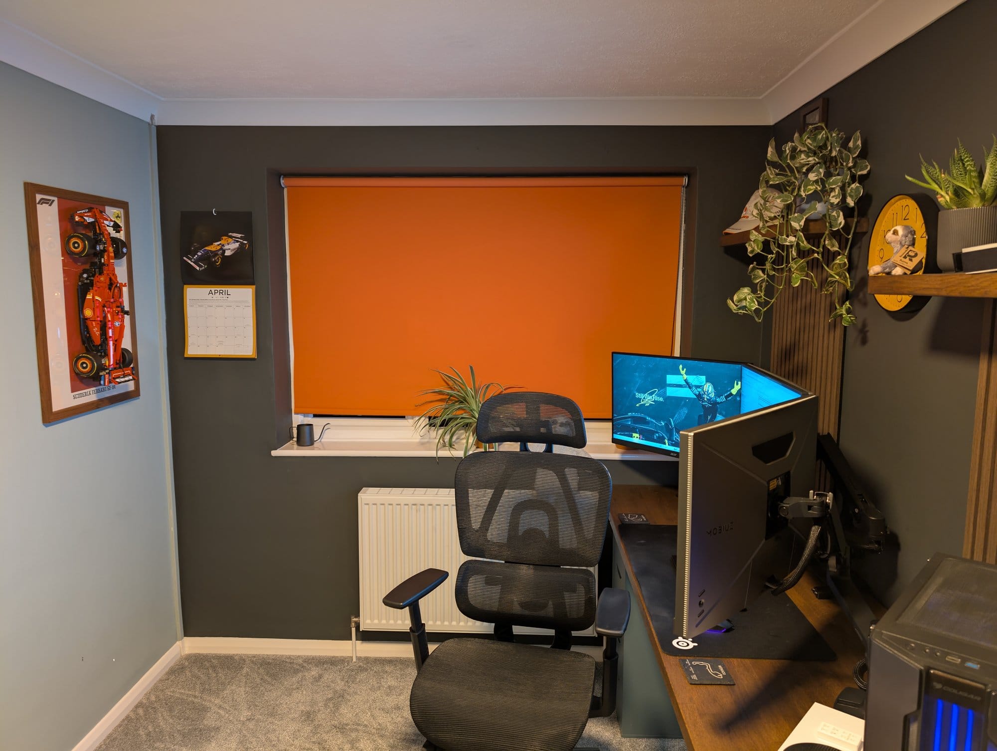 A home office with a BenQ EX2710Q monitor, Boulies EP460 chair, and F1 wall art