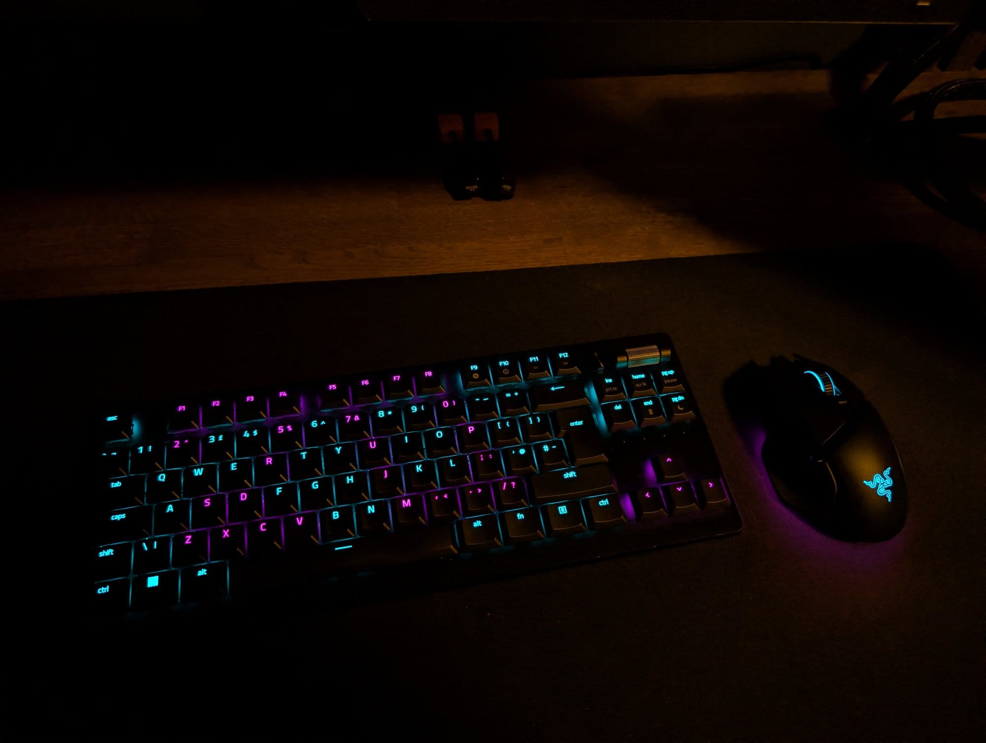 A lit-up Razer Deathstalker V2 Pro keyboard and Razer Basilisk V3 Pro mouse on a SteelSeries desk mat