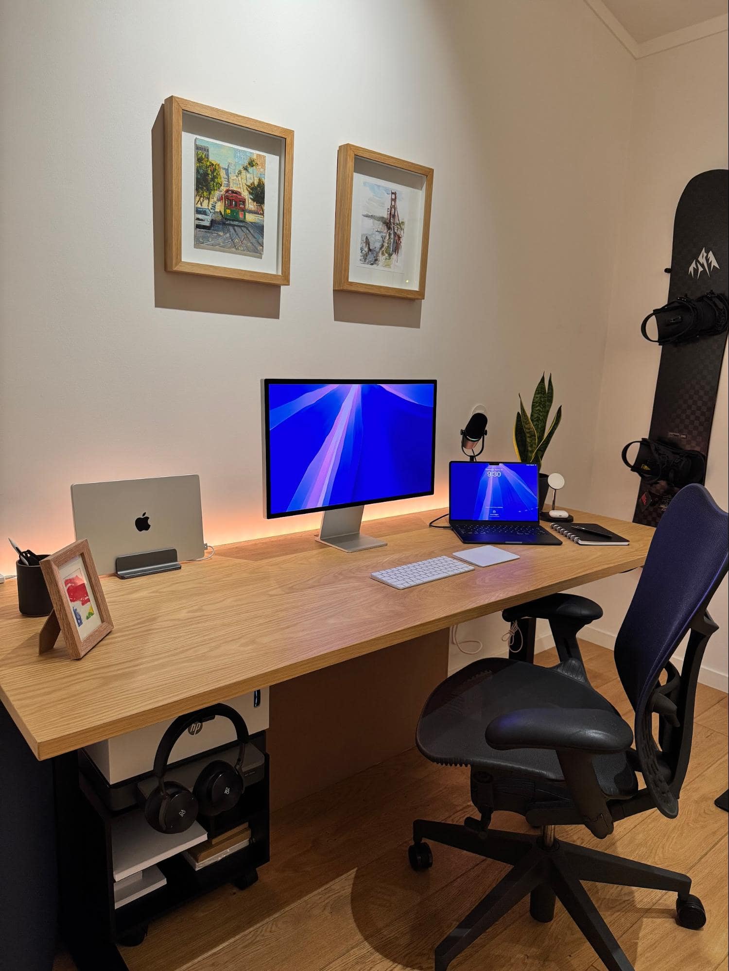 A well-organised desk setup with an Apple Studio Display, a MacBook Air M4, and a Herman Miller Aeron office chair