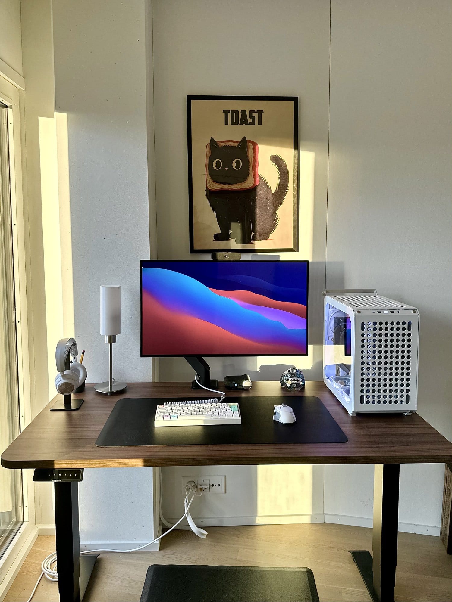 A workspace with a Cooler Master QUBE 500 Flatpack PC case, LG UltraGear 32GS95UE-B monitor and custom 60% keyboard on a dark desk mat
