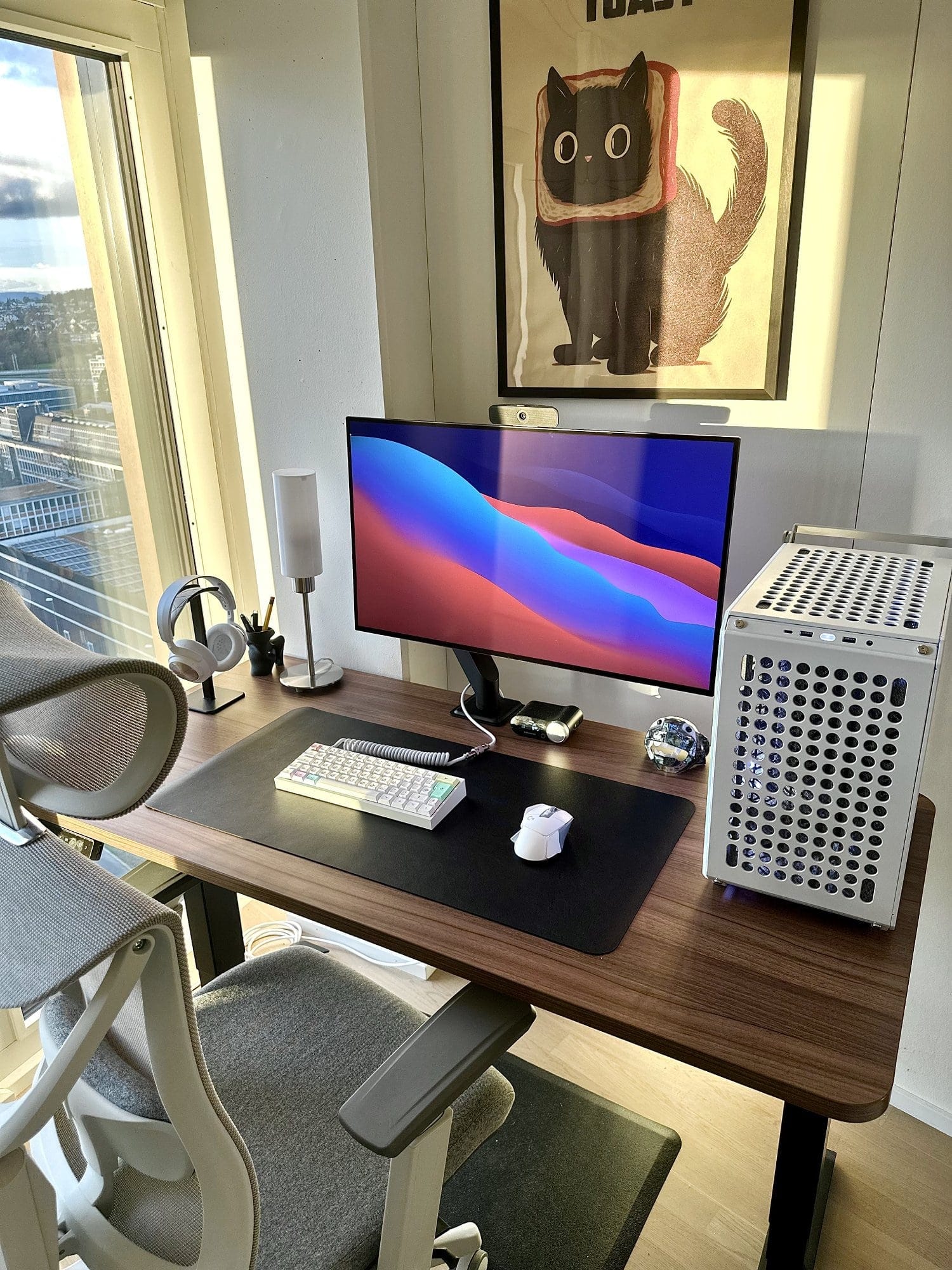 A home office desk setup with a Cooler Master QUBE 500 Flatpack PC case, LG UltraGear 32GS95UE-B monitor, a custom 60% keyboard with PBT Cherry Milkshake keycaps, and a cat-themed poster on the wall