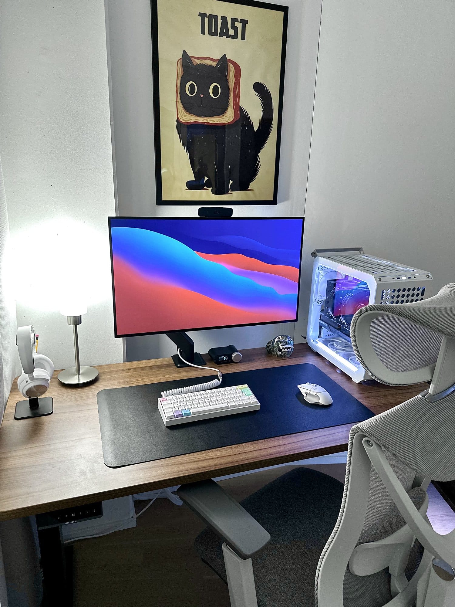 A home workspace with a TOAST cat poster, LG UltraGear 32GS95UE-B monitor and Cooler Master QUBE 500 Flatpack PC case
