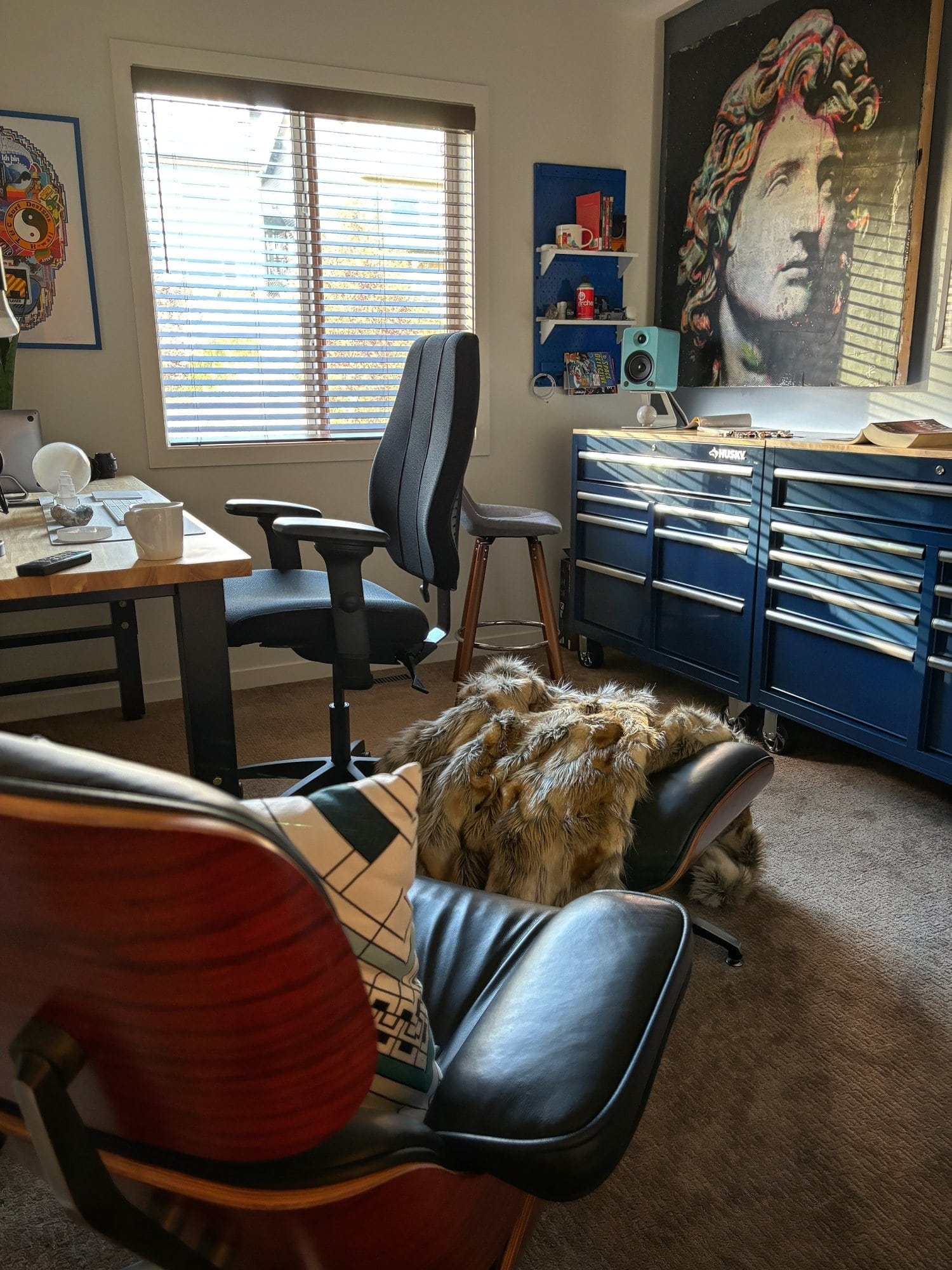 A functional desk setup with a blue metal pegboard by Wall Control