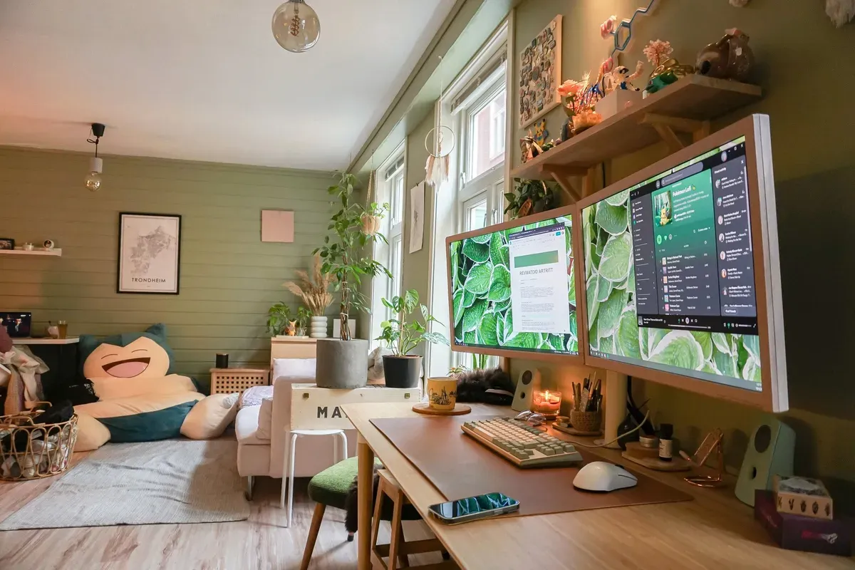 A cosy home office with dual monitors, leafy wallpaper, and a Snorlax bean bag