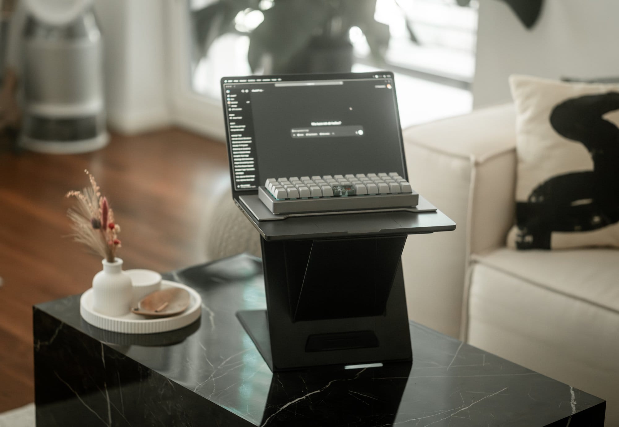 A MacBook Pro and OLKB Planck keyboard on a black MOFT stand