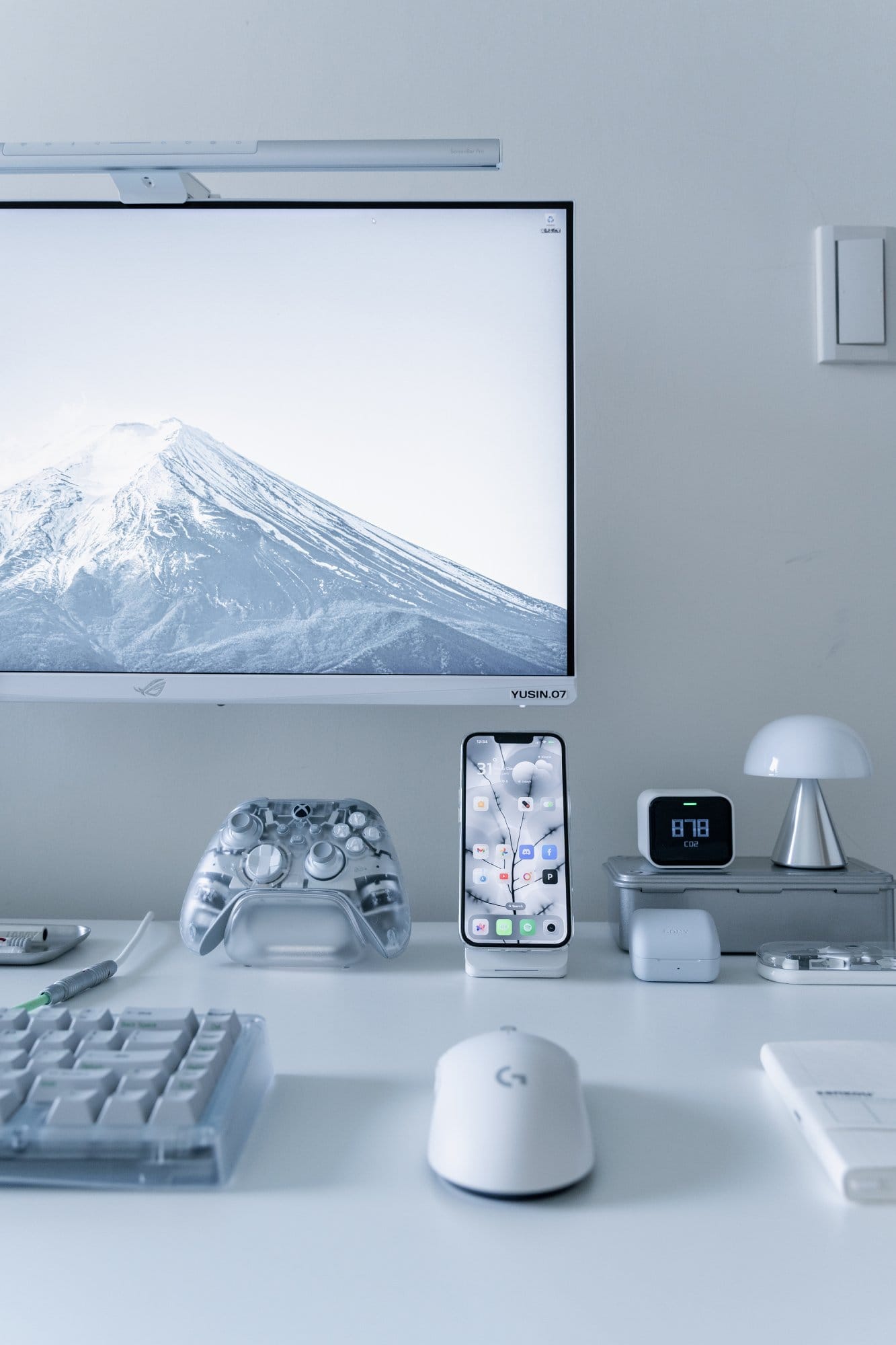 A partial desk view showing a Bauer Lite keyboard, Logitech G Pro X Superlight mouse and transparent Xbox Ghost Cipher controller