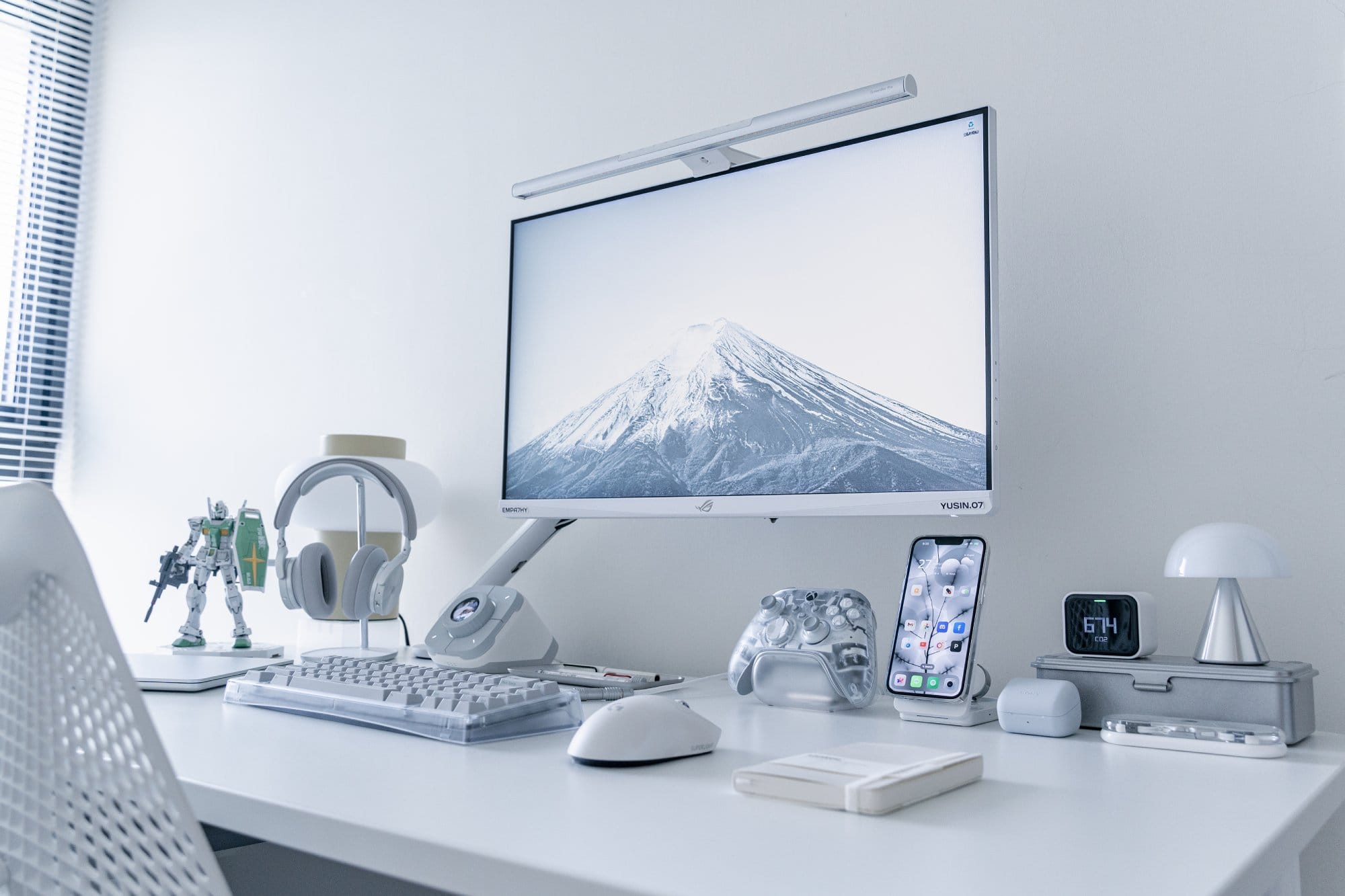 A white desk with an ASUS ROG XG279Q-GD monitor on a Herman Miller Flo arm, B&O H95 headphones and a Bauer Lite keyboard