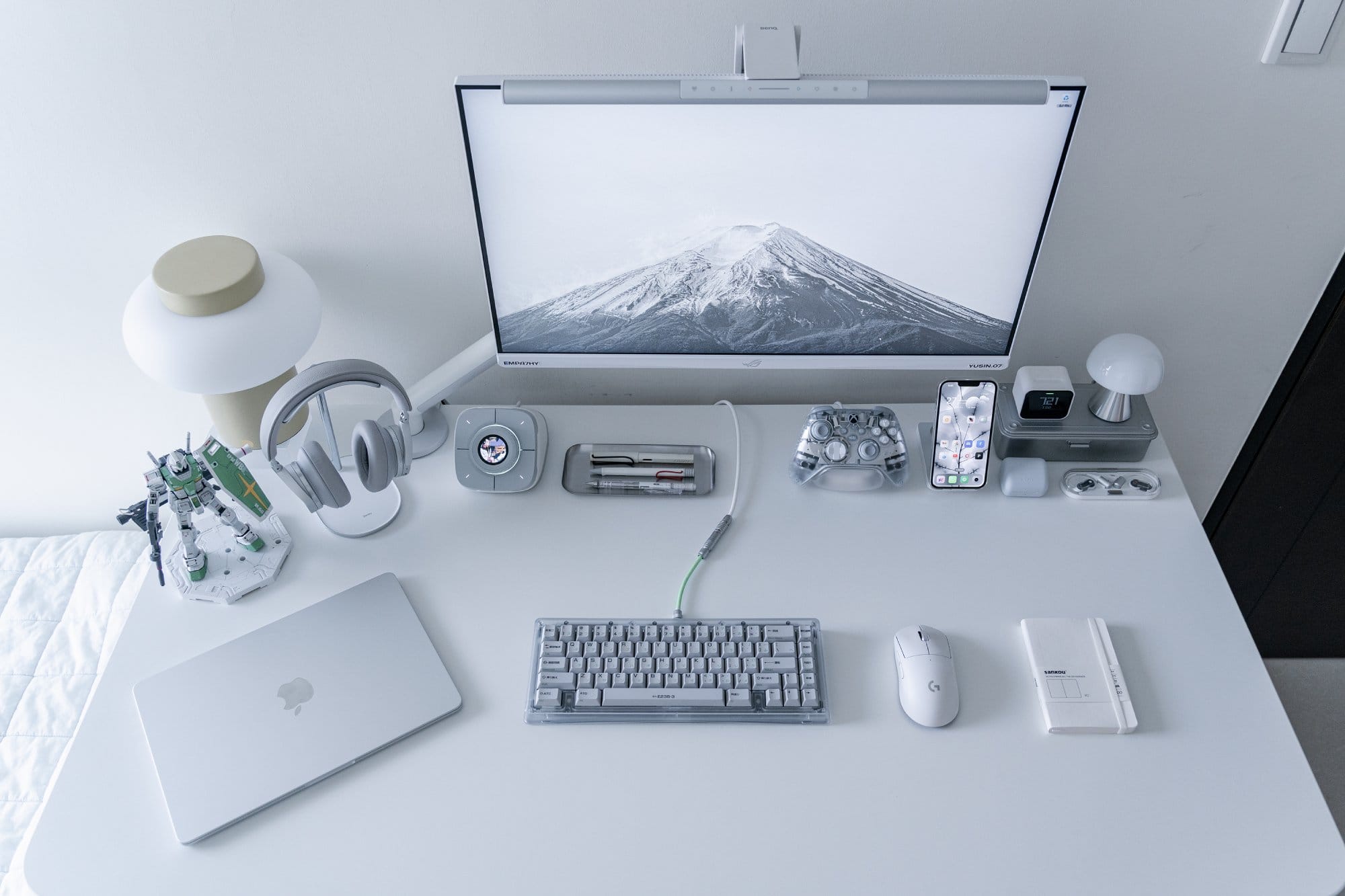 A white home desk with an ASUS ROG XG279Q-GD monitor on a Herman Miller Flo arm, B&O H95 headphones and a Bauer Lite keyboard