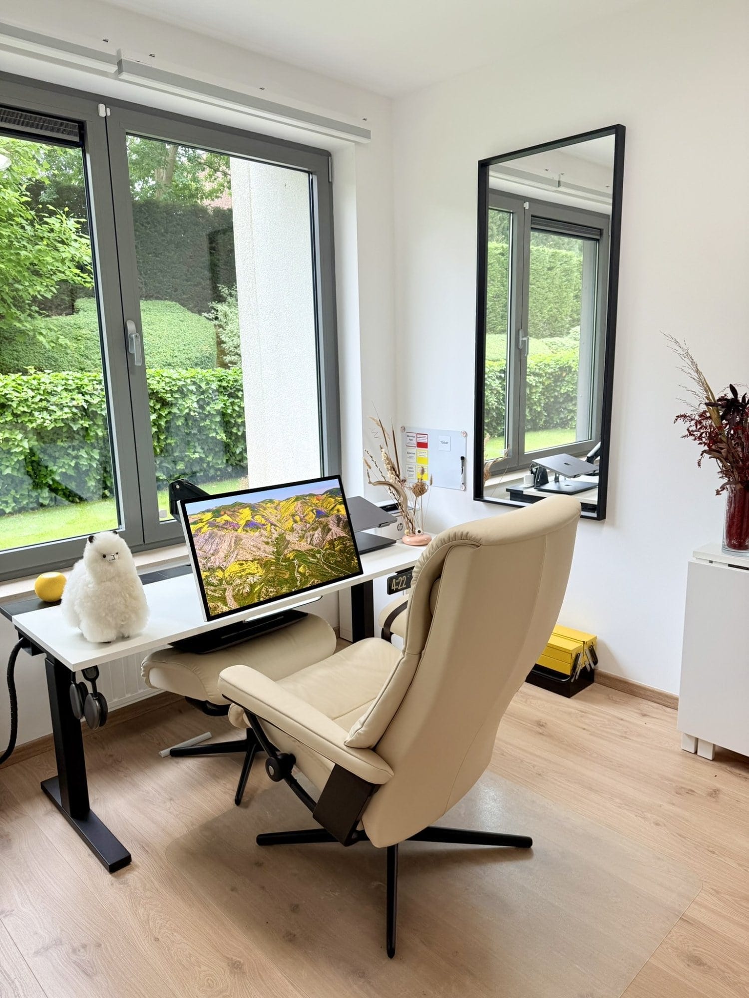 A zero gravity desk setup with an Apple Studio Display and soft plush alpaca
