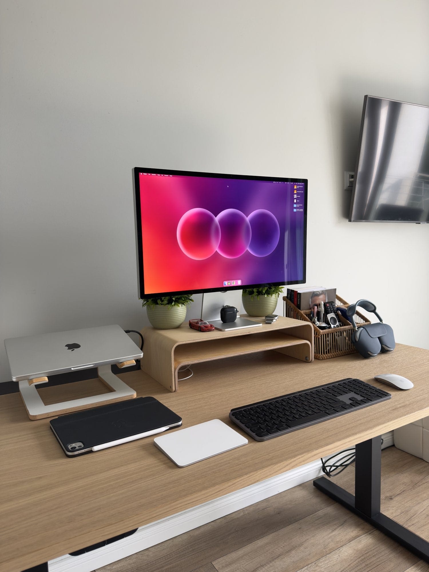 home office desk setup featuring Apple Studio Display, wireless keyboard and mouse, AirPods Max, ring light, and neatly organised workspace accessories