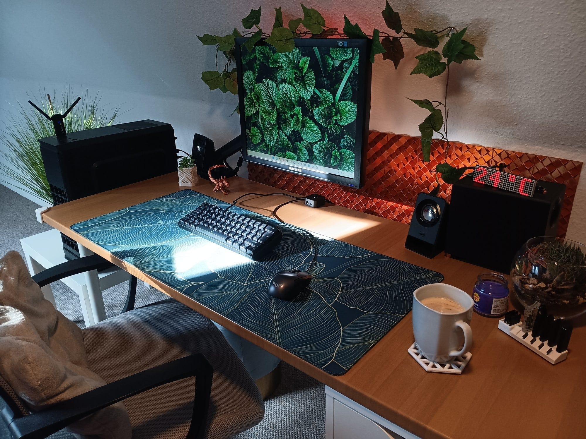 sun lit cosy desk setup with single monitor, compact keyboard, ergonomic chair, wood desk with plants, and coffee mug