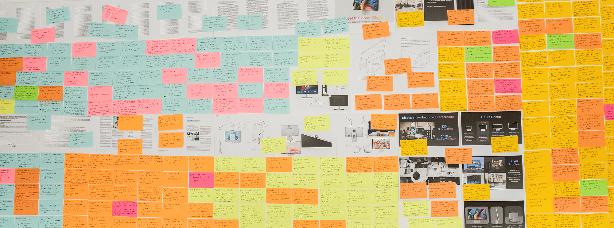 white board covered with colourful sticky notes and product design references for planning and development