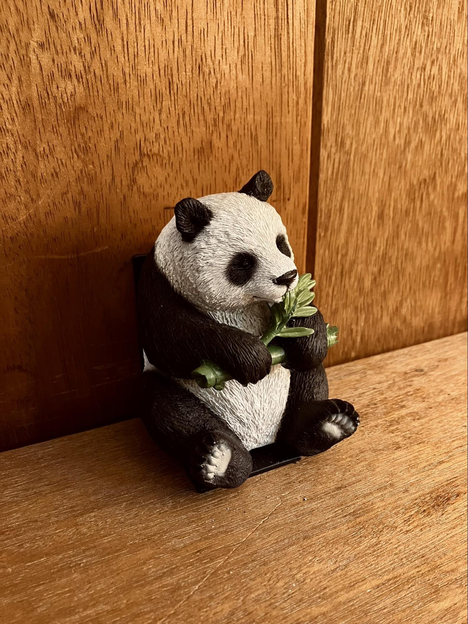 panda figurine holding bamboo sitting on wooden surface