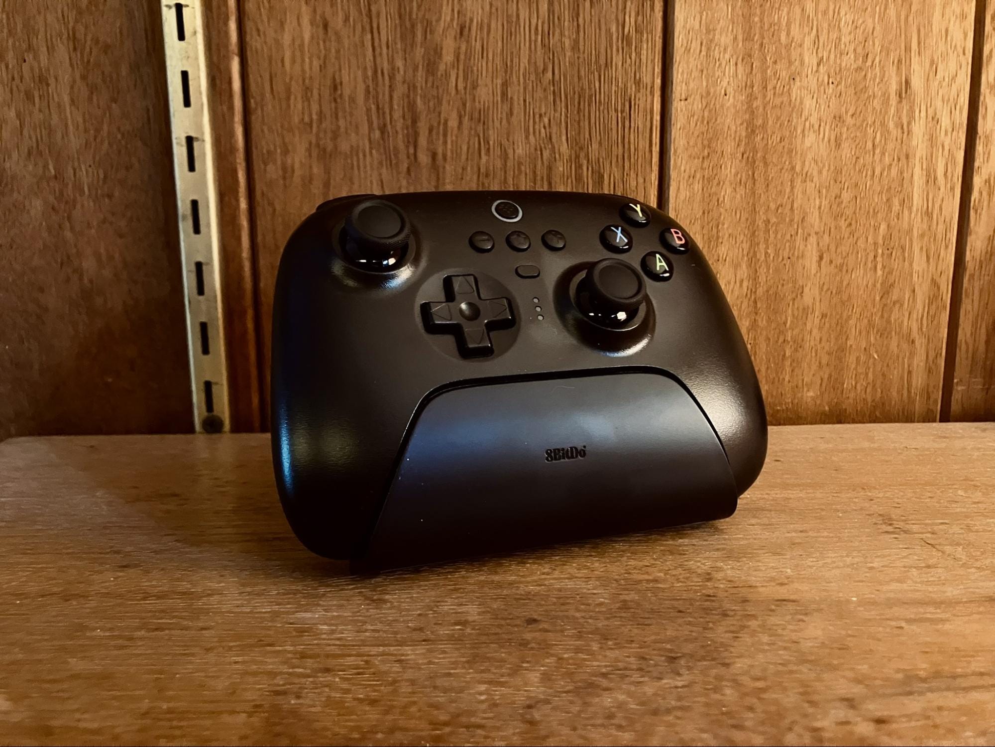 black 8BitDo wireless controller on wooden surface