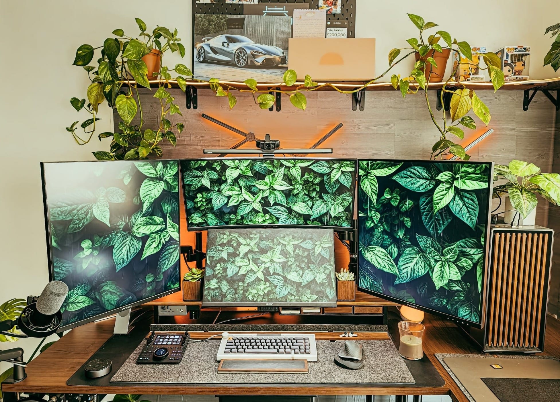 modern desk setup with four monitors, mechanical keyboard, streaming microphone, custom pc, indoor plants, and ambient lighting