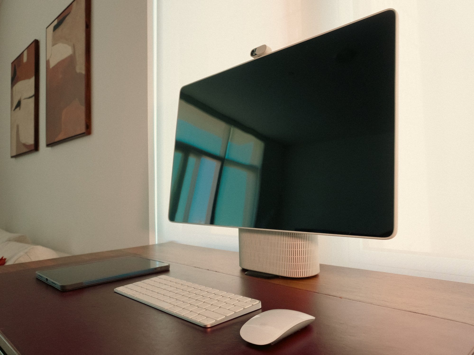 side view of the HomeTechCo Home Display on a desk with a keyboard, mouse, and tablet