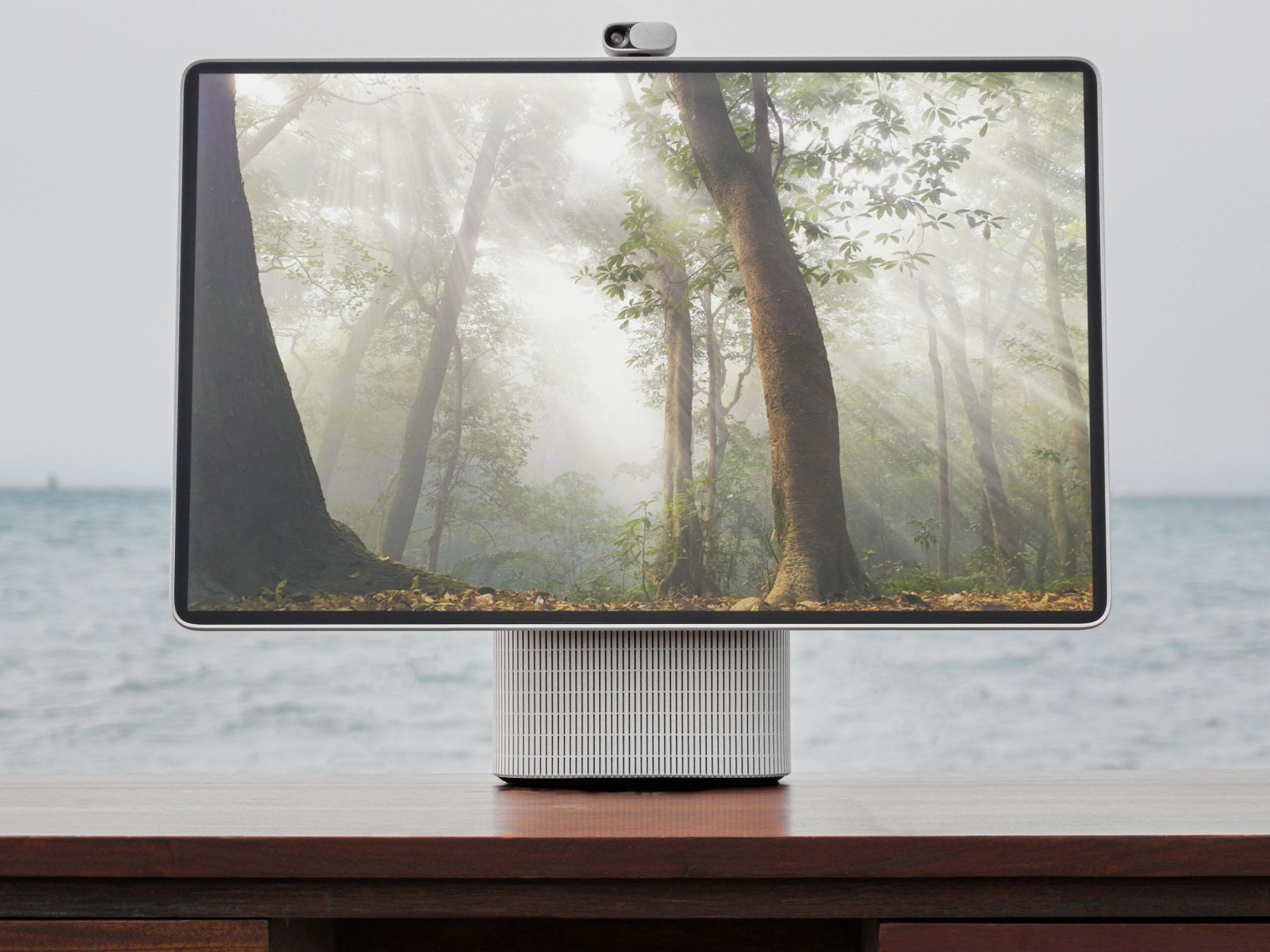close-up of the HomeTechCo Home Display on a wooden desk with the ocean in the background